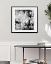 Framed black and white abstract art on a wall above a console table.