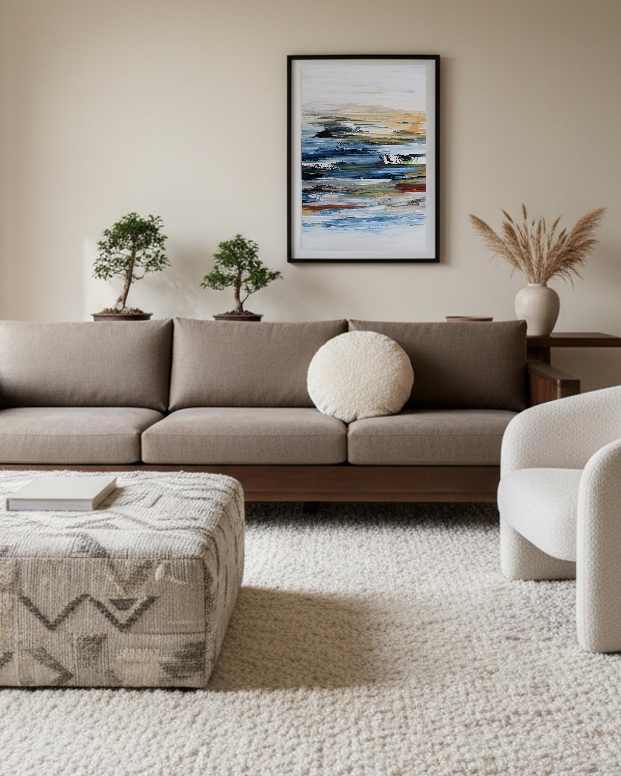 large blue seascape wall art on wall, in modern japandi style living room aesthetic with brown sofa and bespoke ottoman in boucle fabric