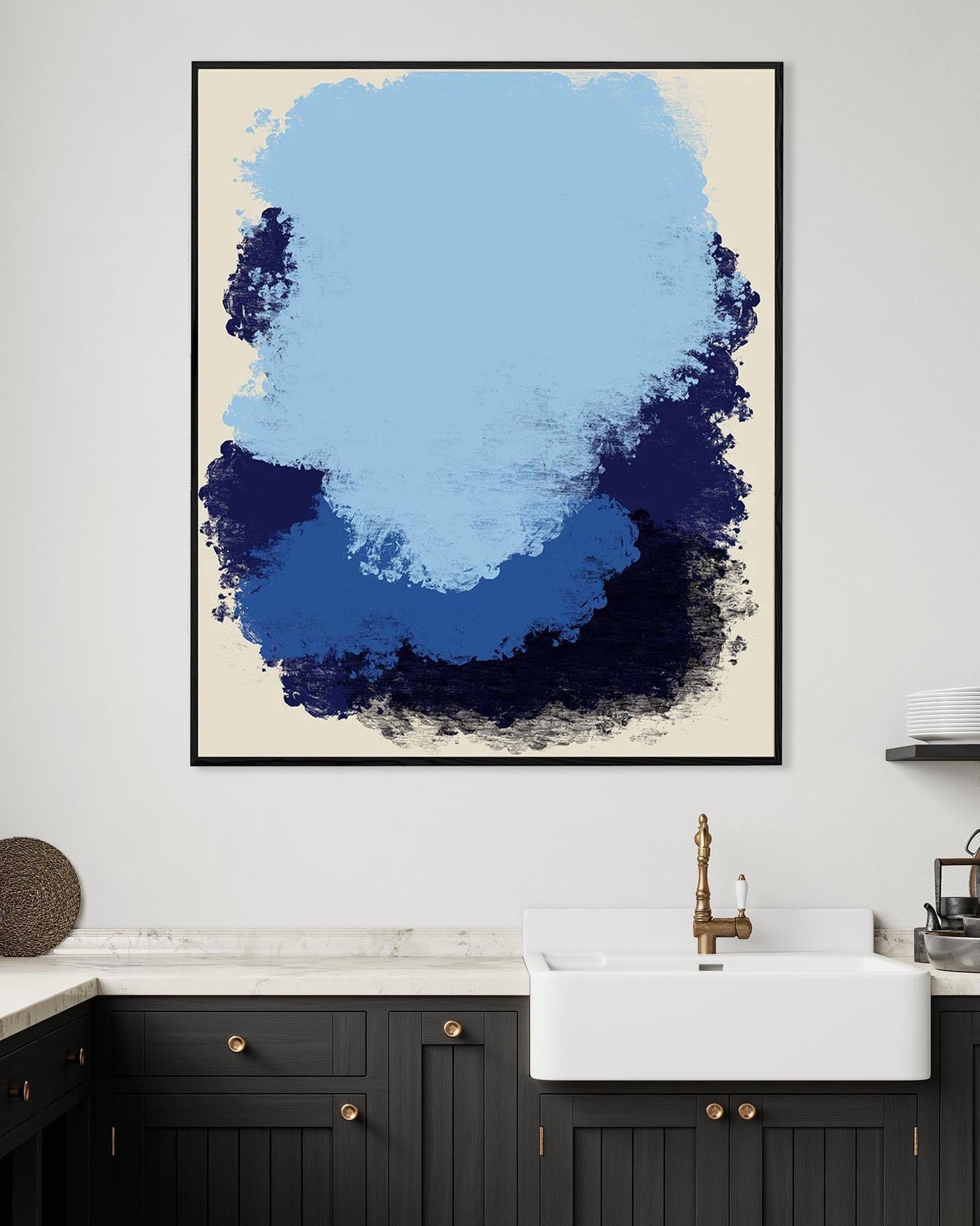 Abstract blue and black art print on a wall above a kitchen sink.