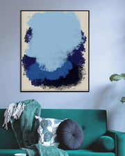 Abstract blue and black painting on a wall above a green sofa with decorative pillows.
