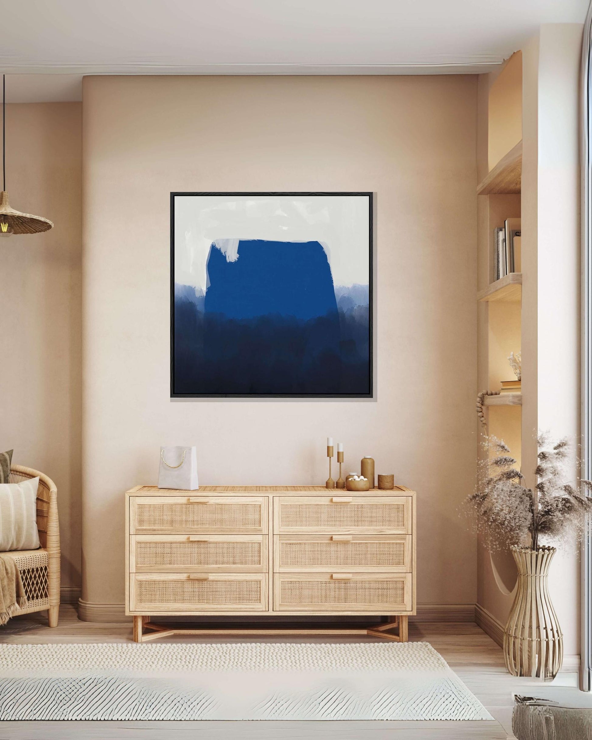 Large modern blue square canvas art print with Scandinavian feel, on blue and white background, displayed in beige neutral living room above sideboard.