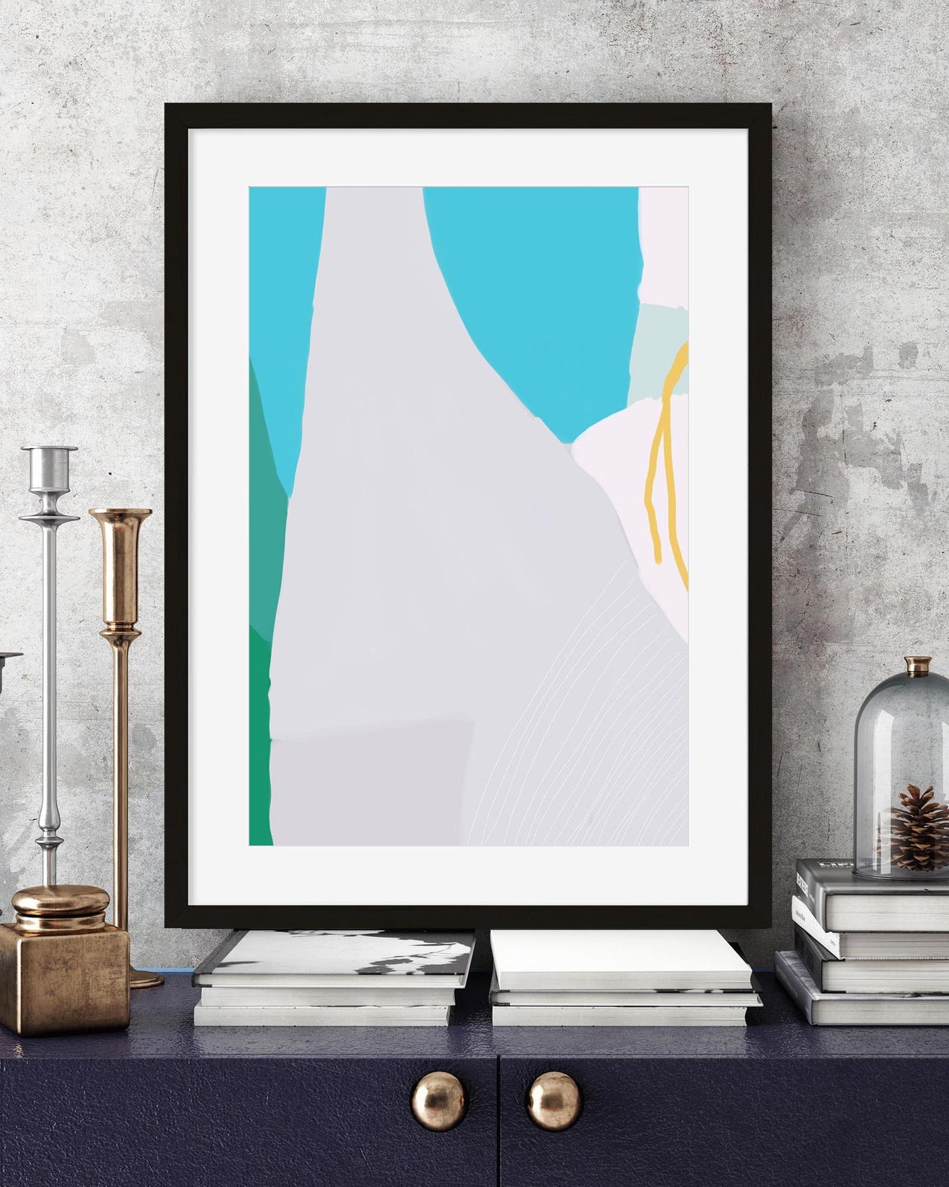 Framed abstract art print on a wall above a shelf with decorative items.
