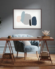 Modern interior with a wooden desk, gray armchair, and abstract art on the wall.