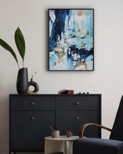 Modern interior with abstract painting, black dresser, and decorative items.