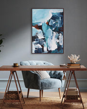 Modern interior with a wooden desk, gray chair, and abstract painting on a gray wall.