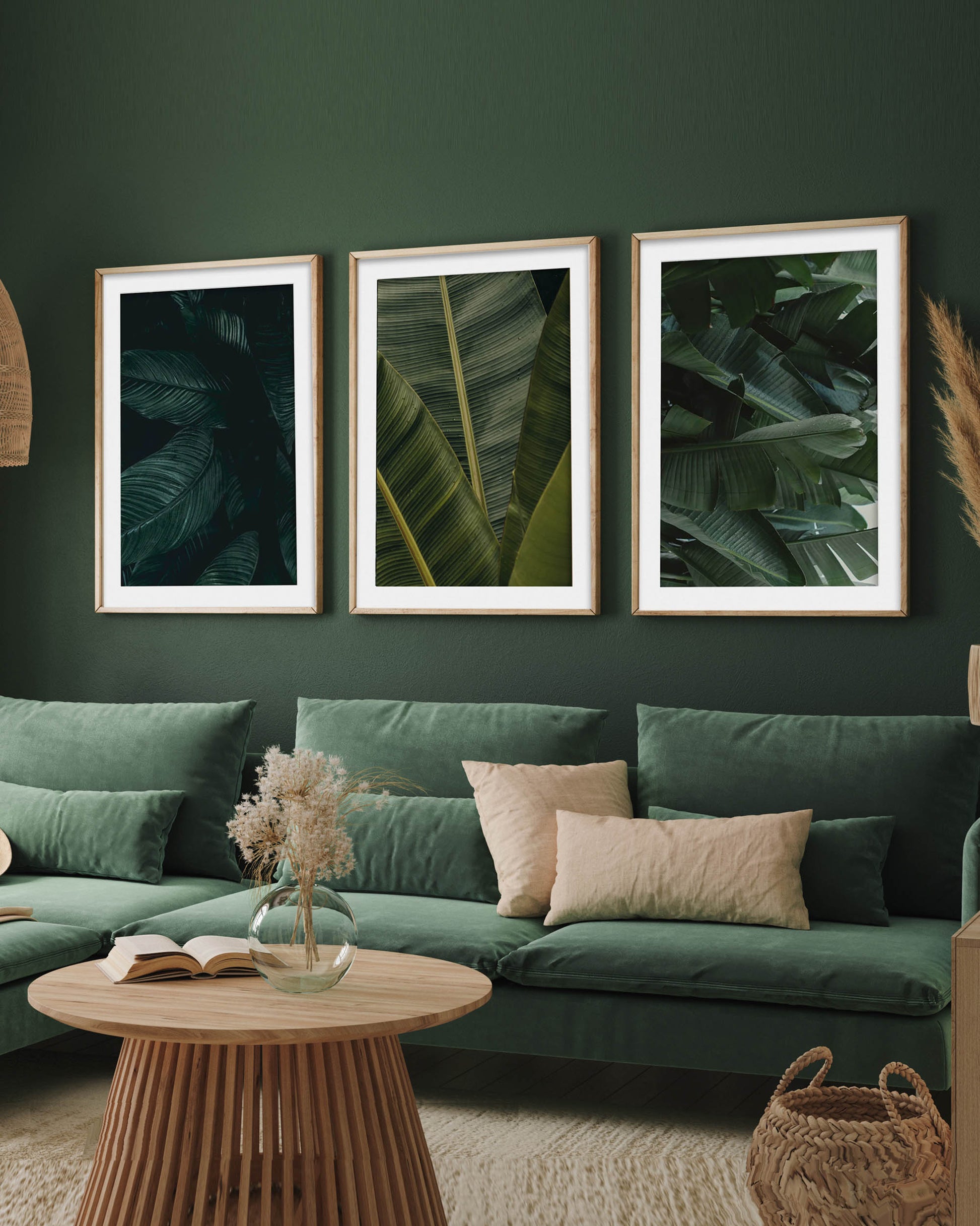 Green living room with a sectional sofa, coffee table, and framed leaf prints on the wall.