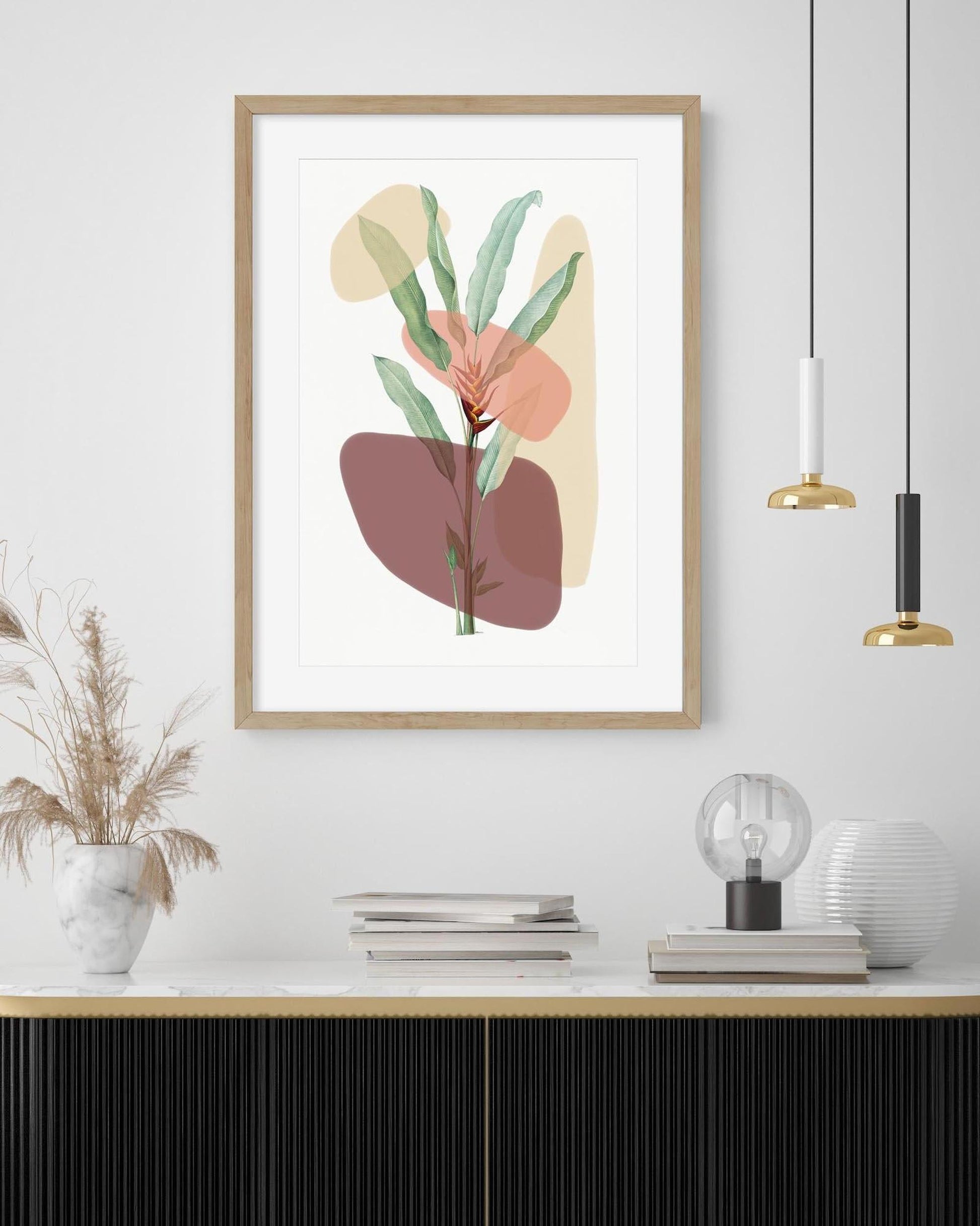 Framed abstract art print with leaves on a wall above a wooden shelf.