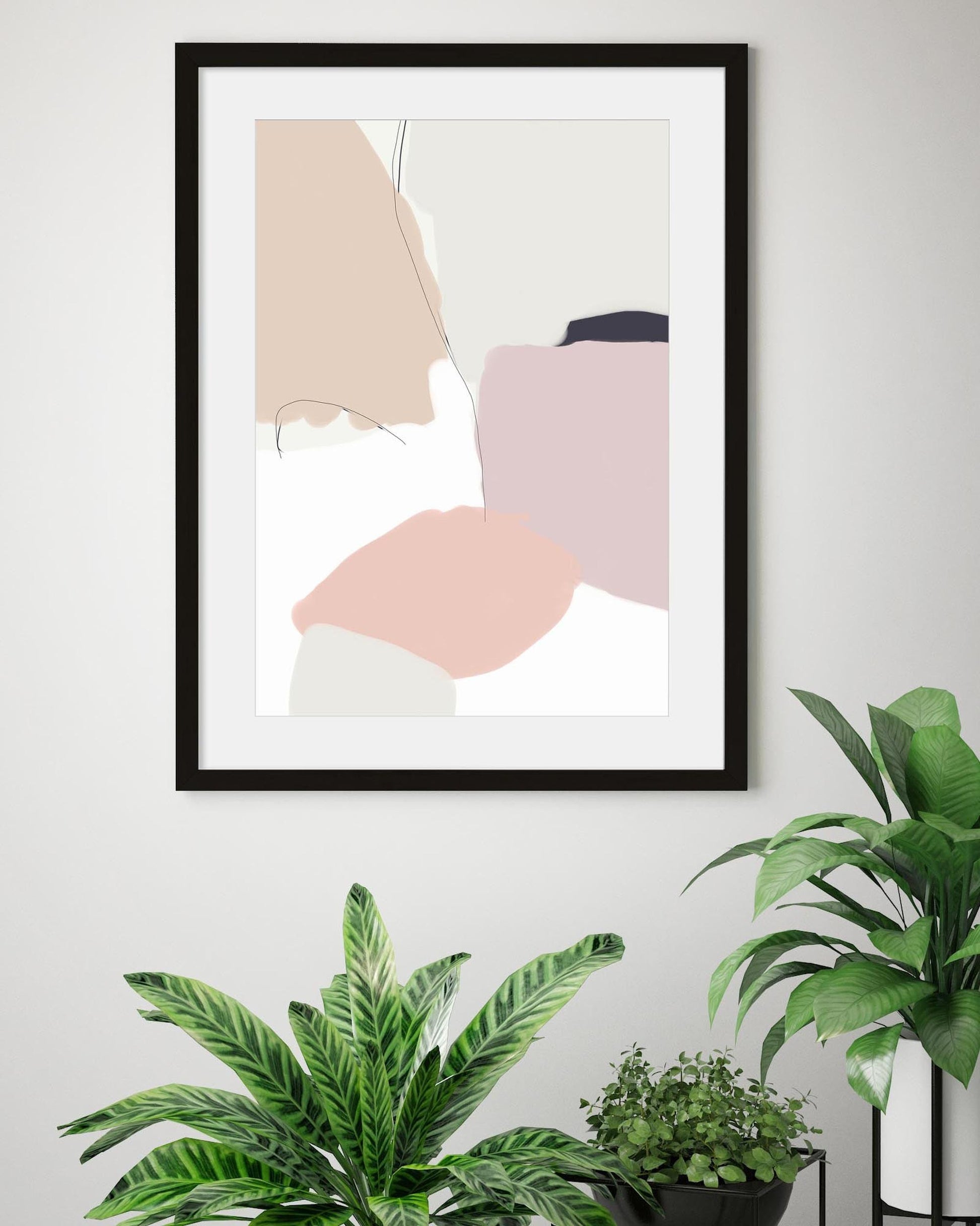 Framed abstract art on a wall with plants below