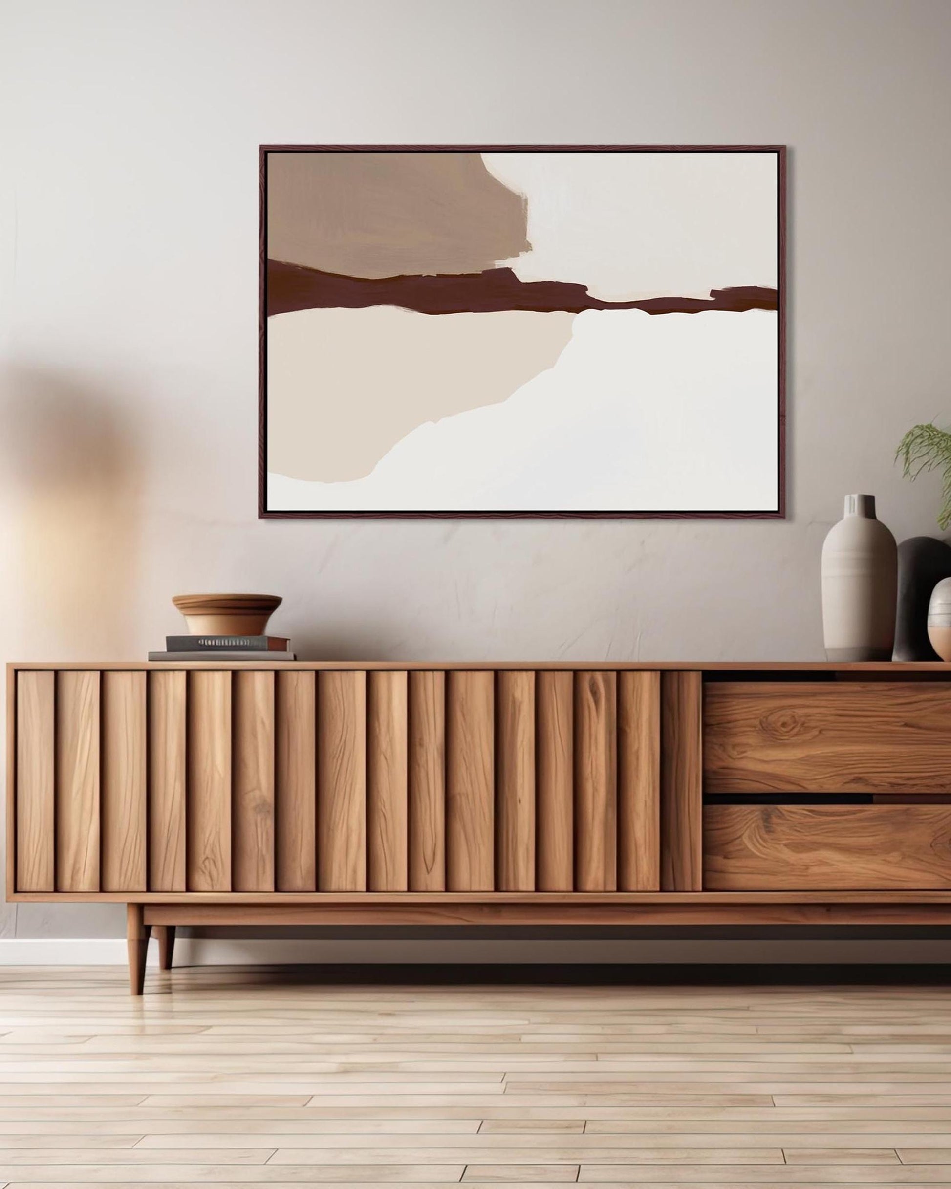 Wooden sideboard in a modern living room with abstract art and decor.