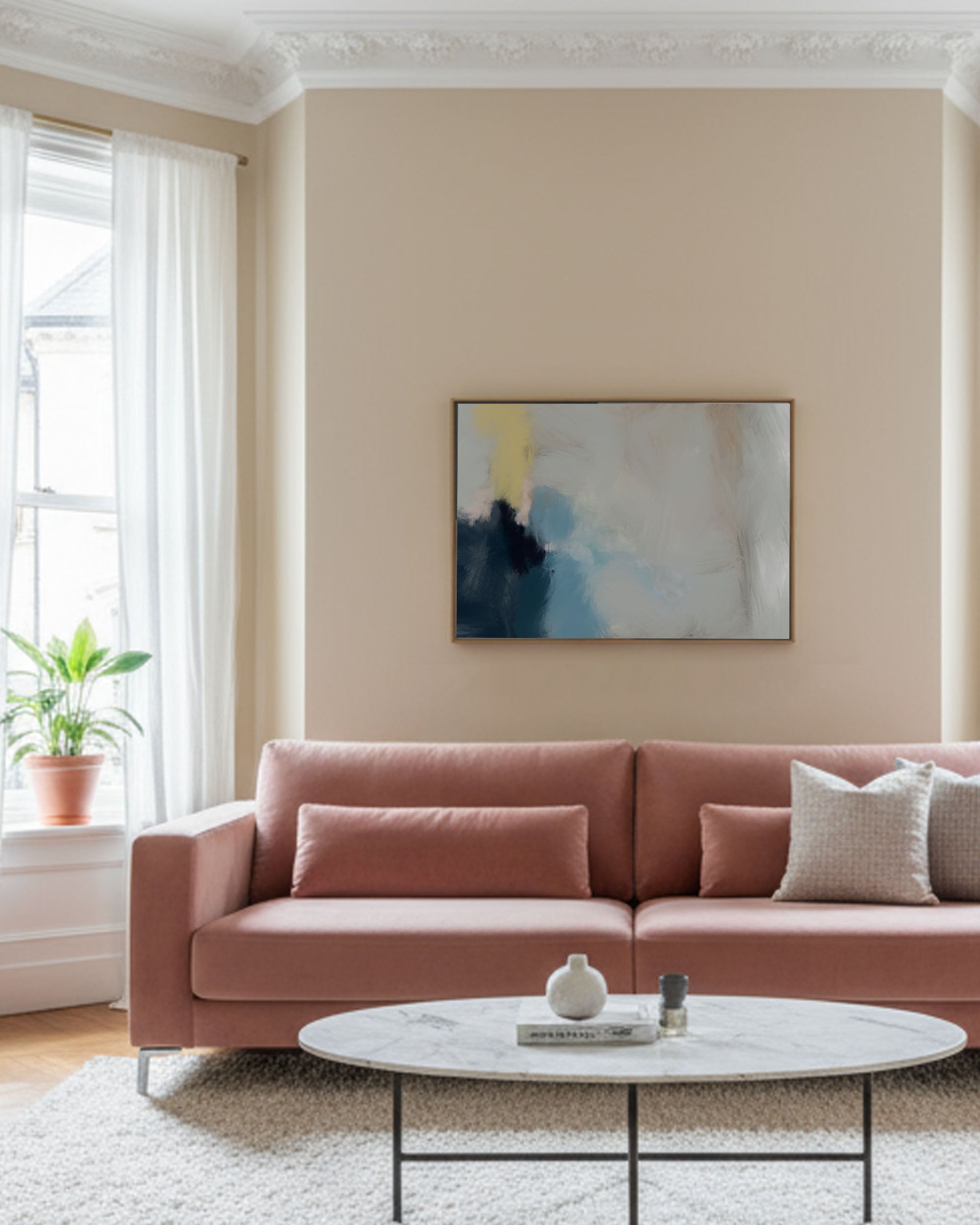 Living room with a pink sofa, round coffee table, and abstract painting on the wall.
