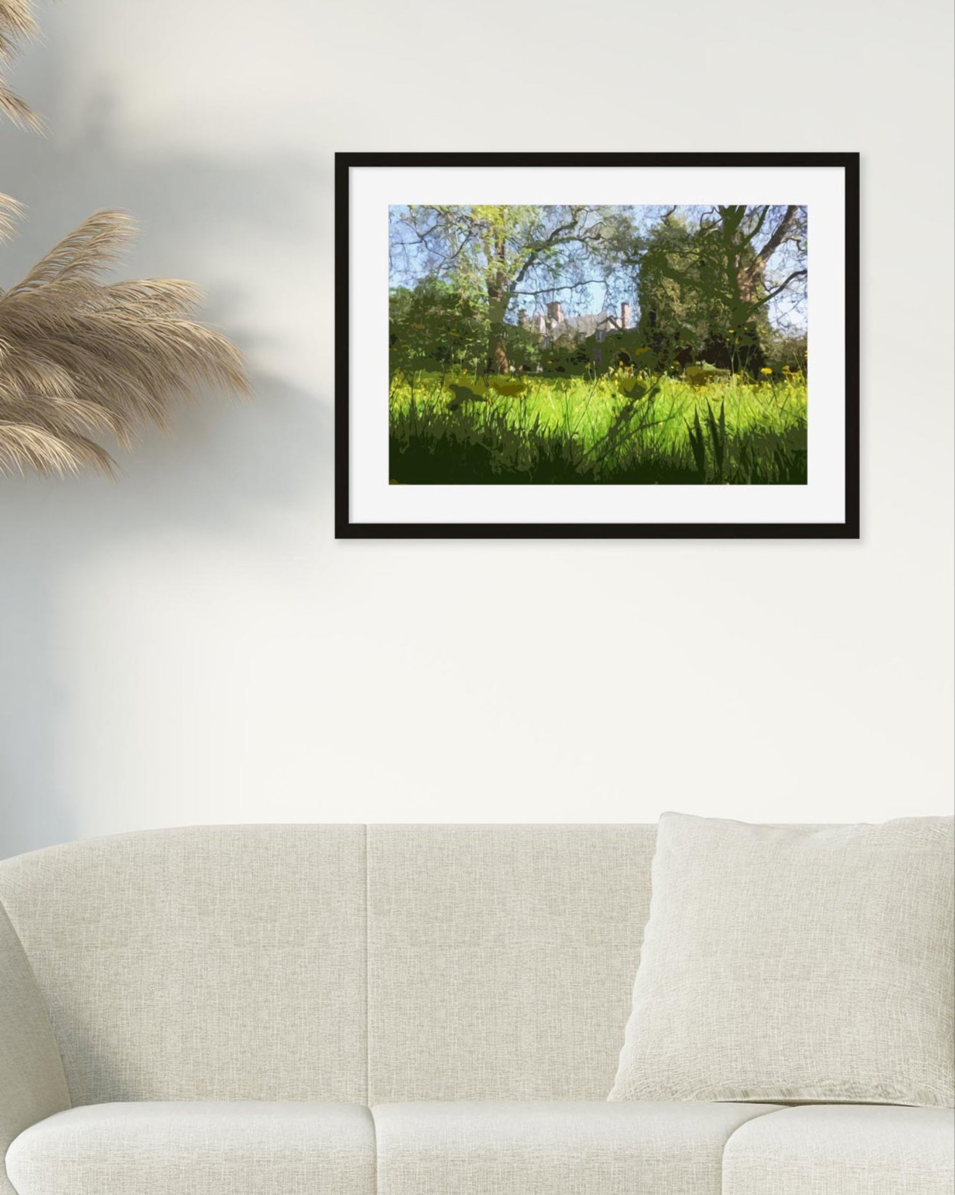 Framed photograph of a park scene above a beige sofa