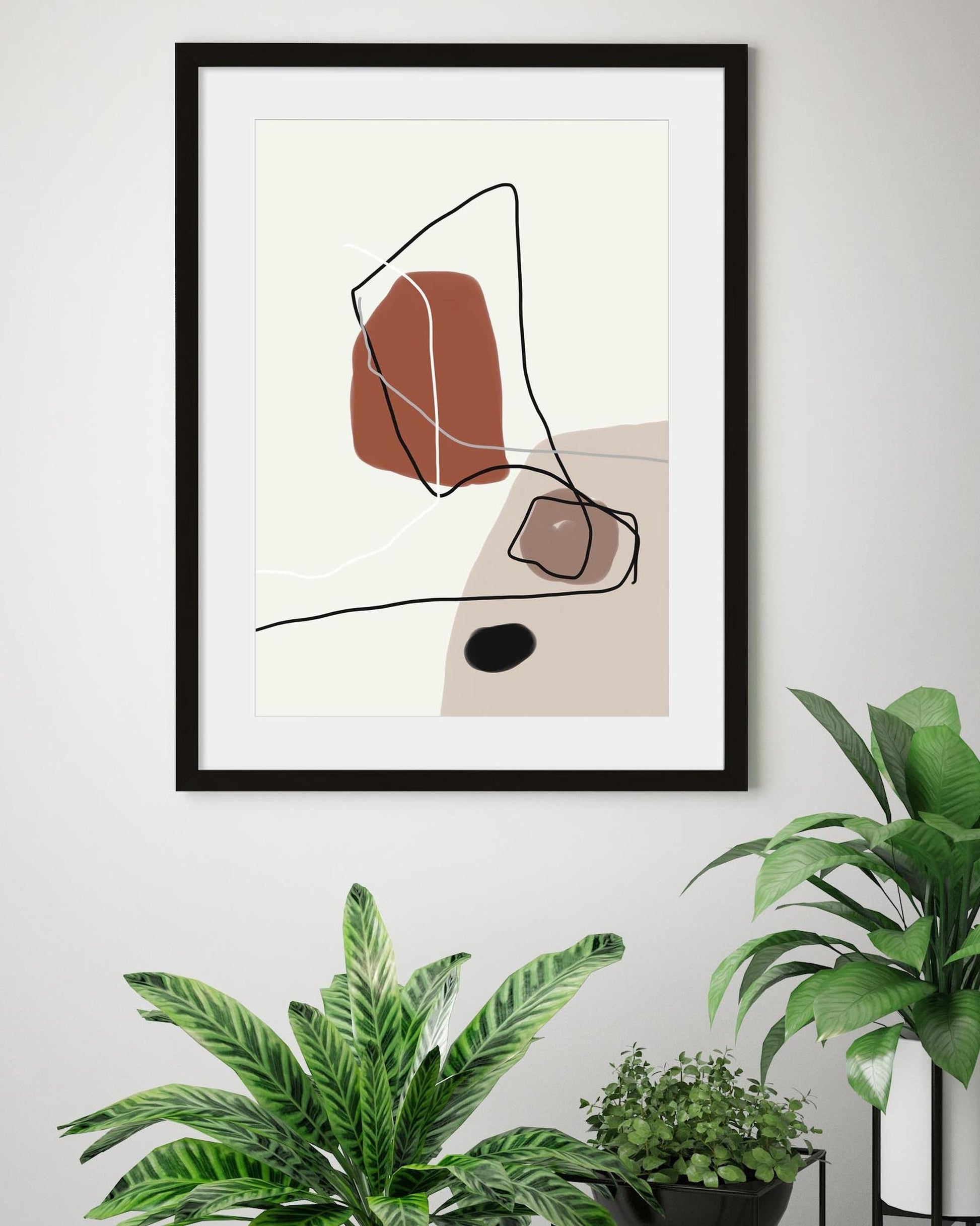 A contemporary art print featuring geometric shapes in burnt orange, beige, and brown tones, mounted on a wall above a green potted plant.