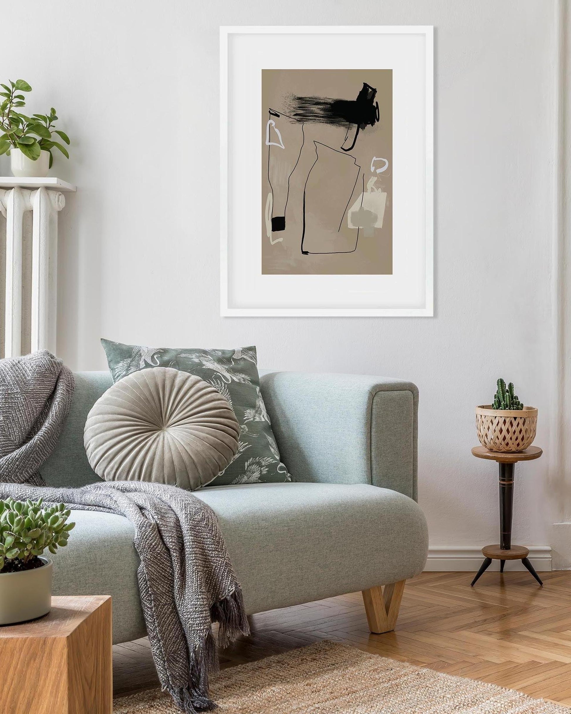 Living room with a sofa, cushions, and a framed abstract art piece on the wall.