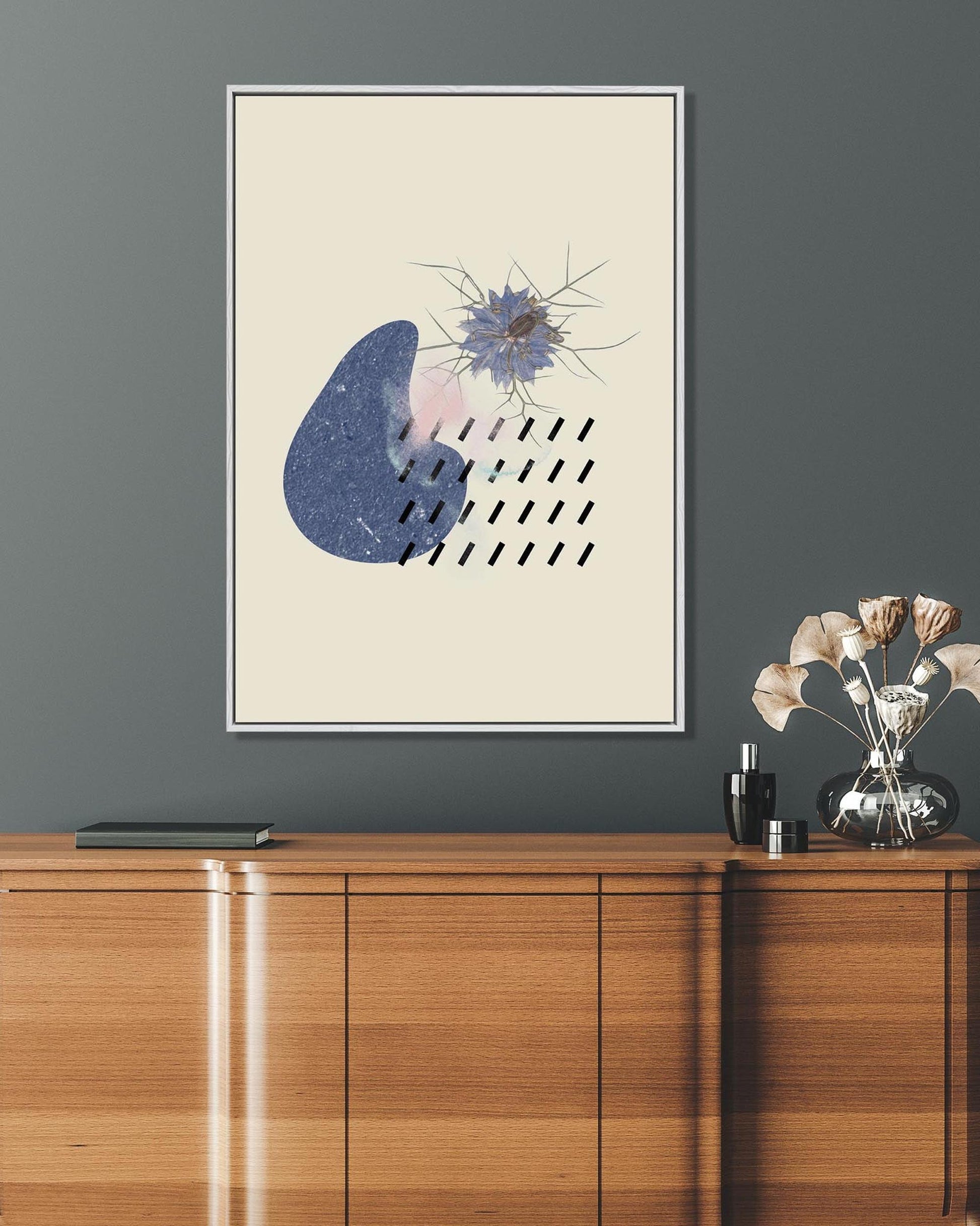 Framed abstract art piece on a gray wall above a wooden console table.