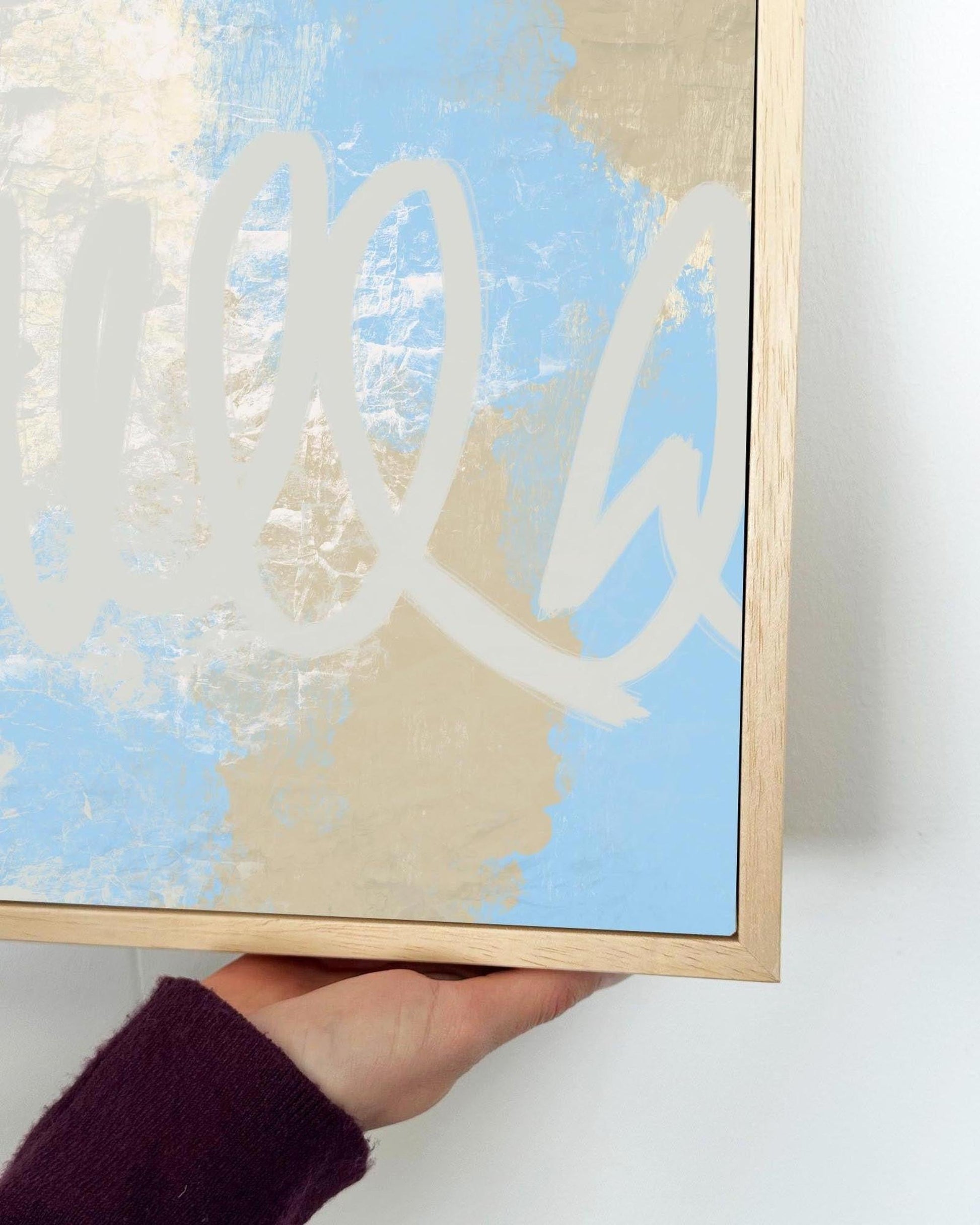 Framed abstract artwork with a hand holding it against a white background