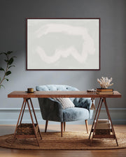 Modern interior with a wooden desk, gray chair, and abstract artwork on a gray wall.