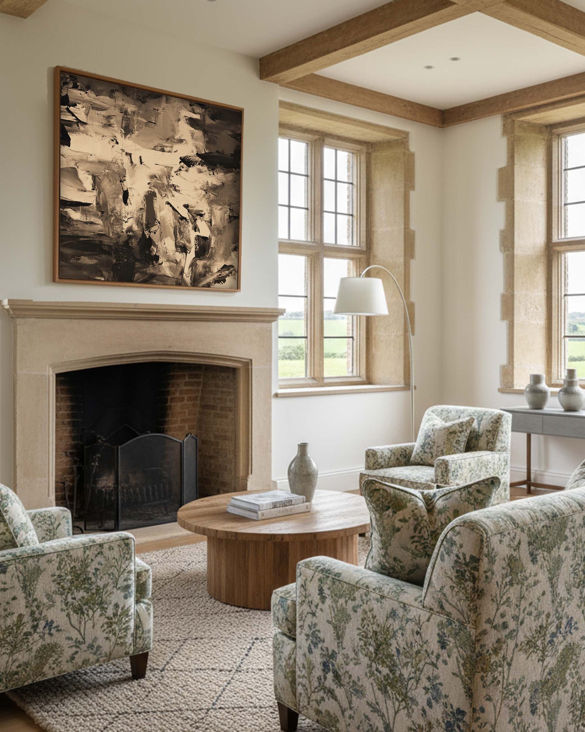 Living room with floral armchairs, a fireplace, and large windows.