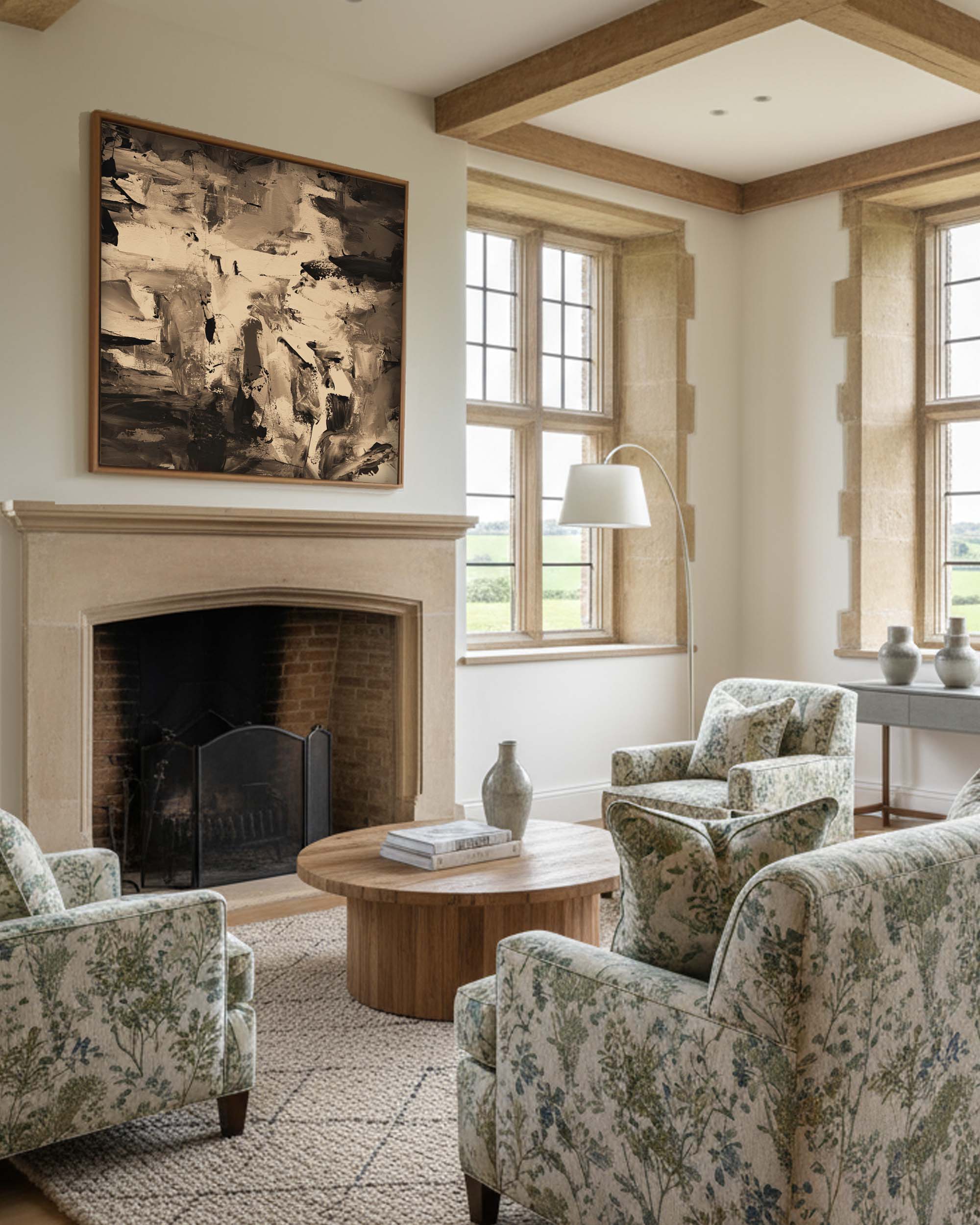 Living room with floral armchairs, a fireplace, and large windows.