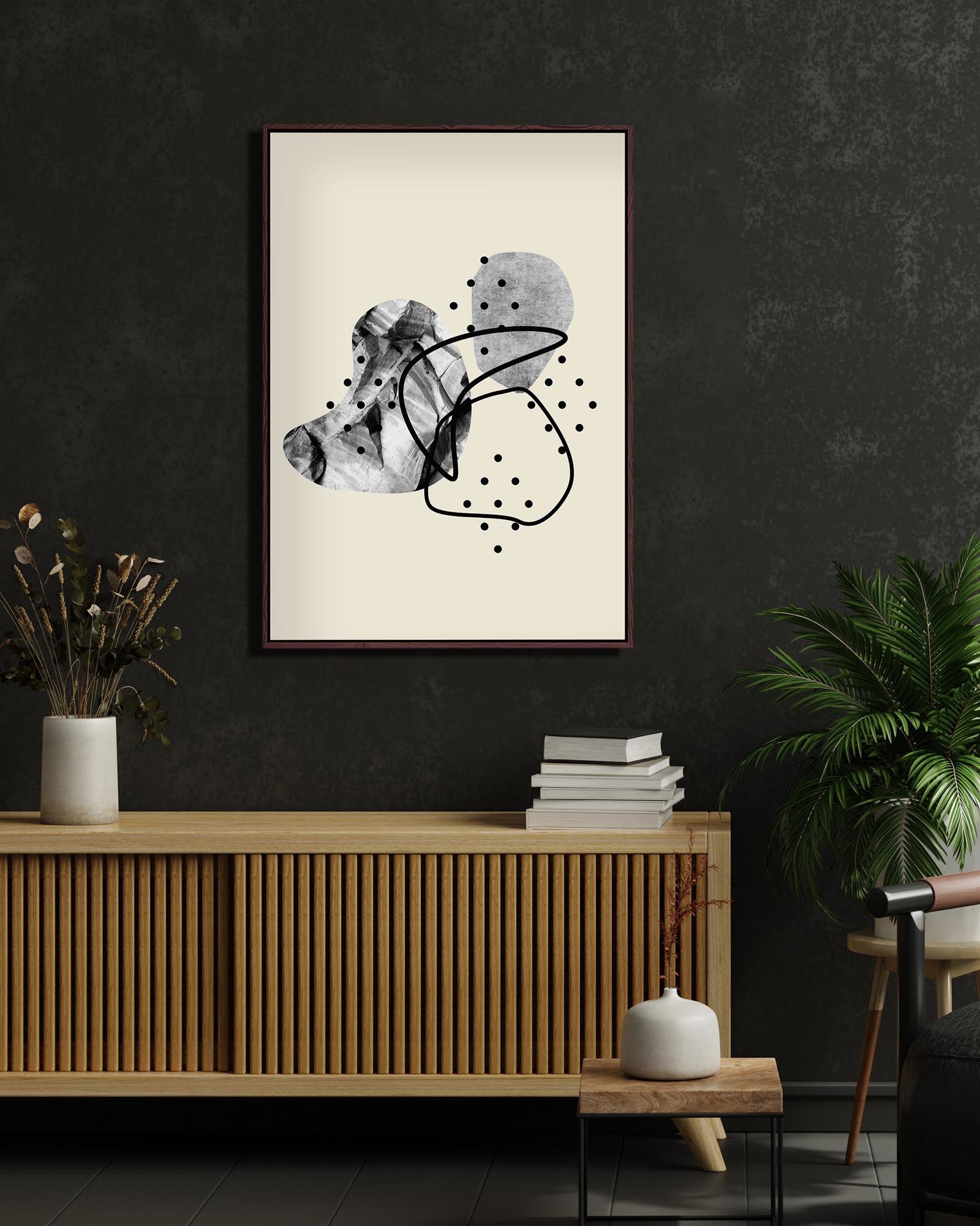 Abstract art print on a wall in a modern interior setting with a wooden cabinet and decor items.