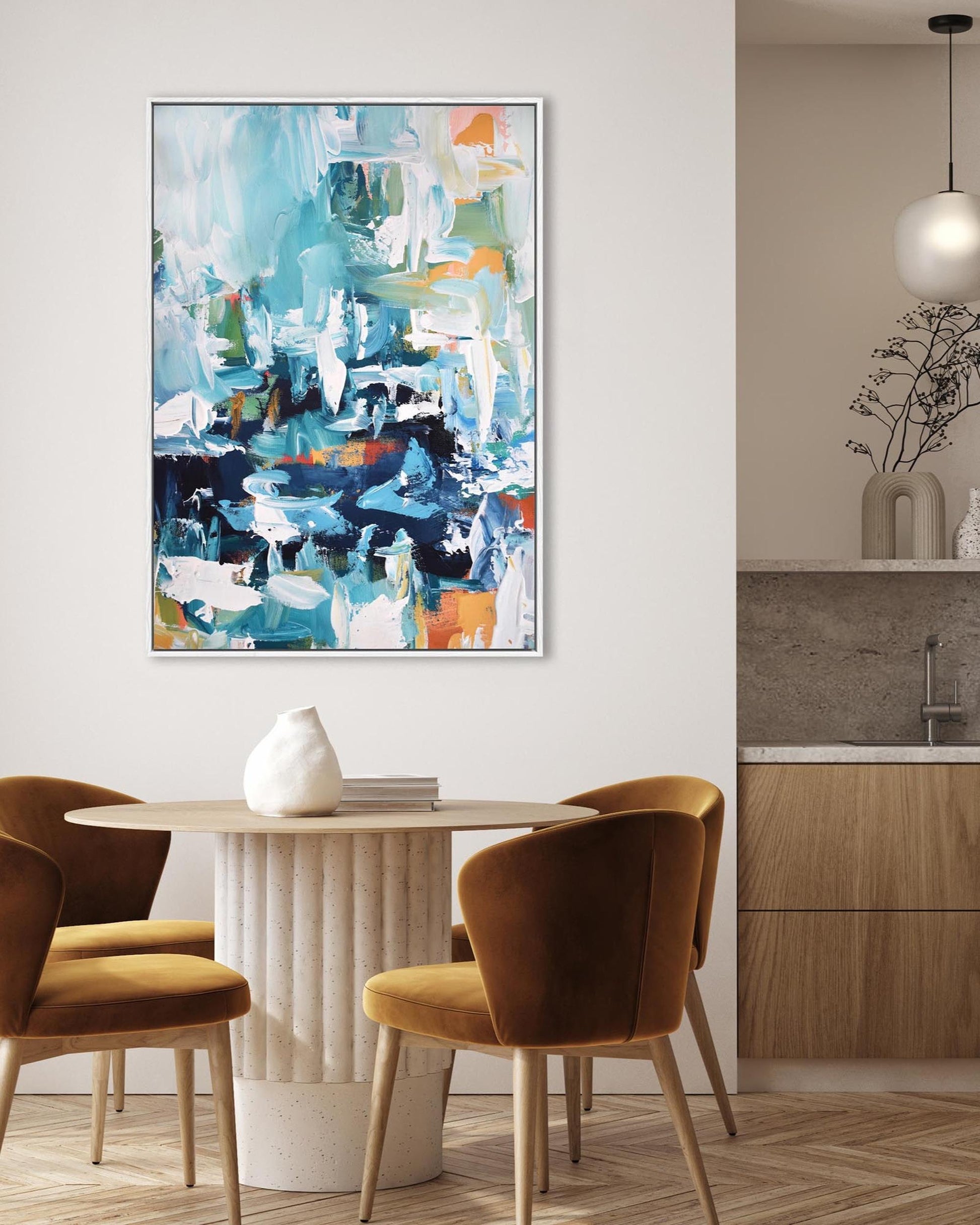 Modern dining area with abstract art on the wall, round table, and chairs.