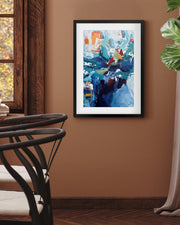 Abstract art print on a wall in a room with a chair and window.