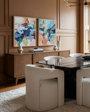 Dining room with a table, chairs, and abstract art on the wall.