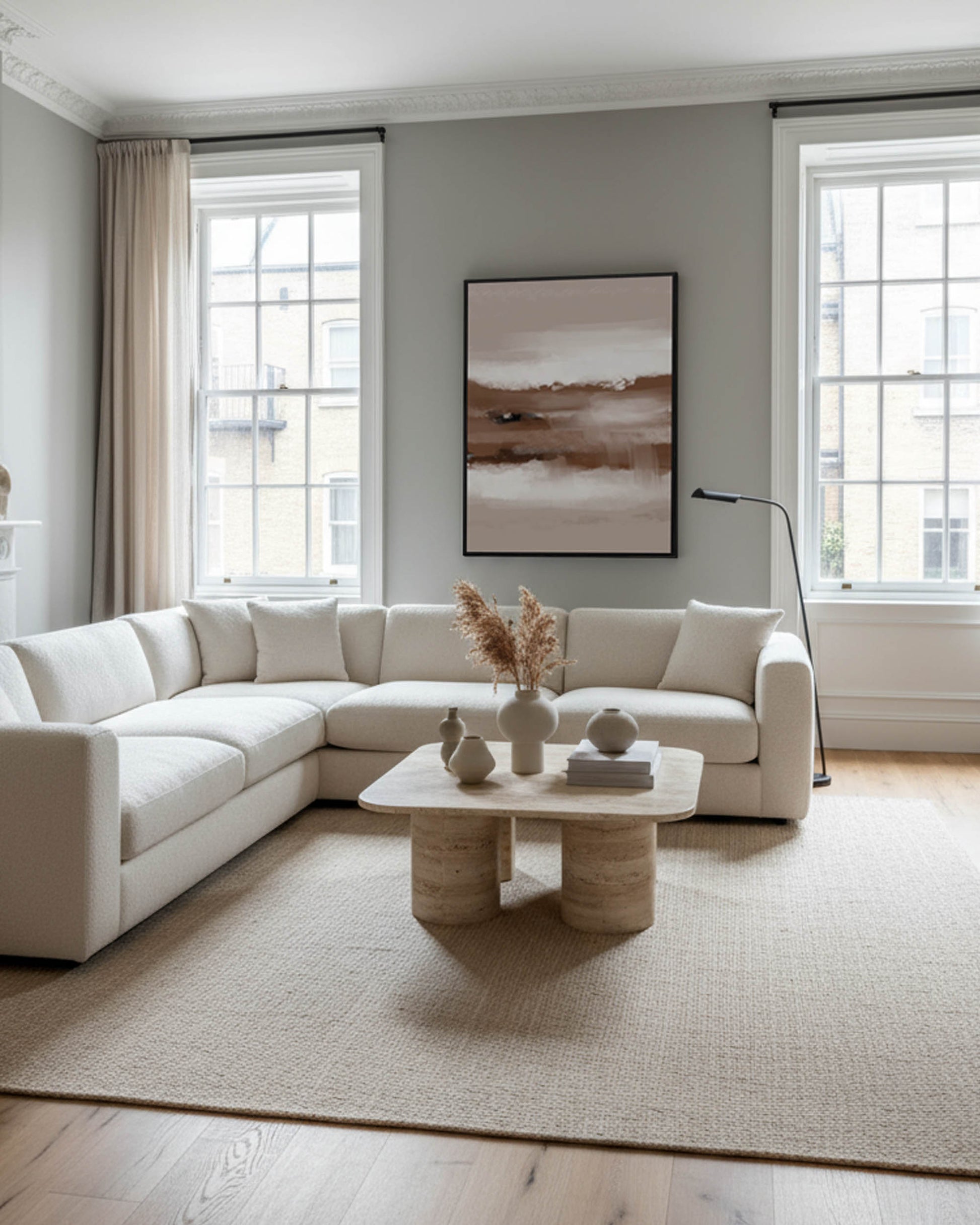 Modern living room with a white sectional sofa, coffee table, and abstract art on the wall.