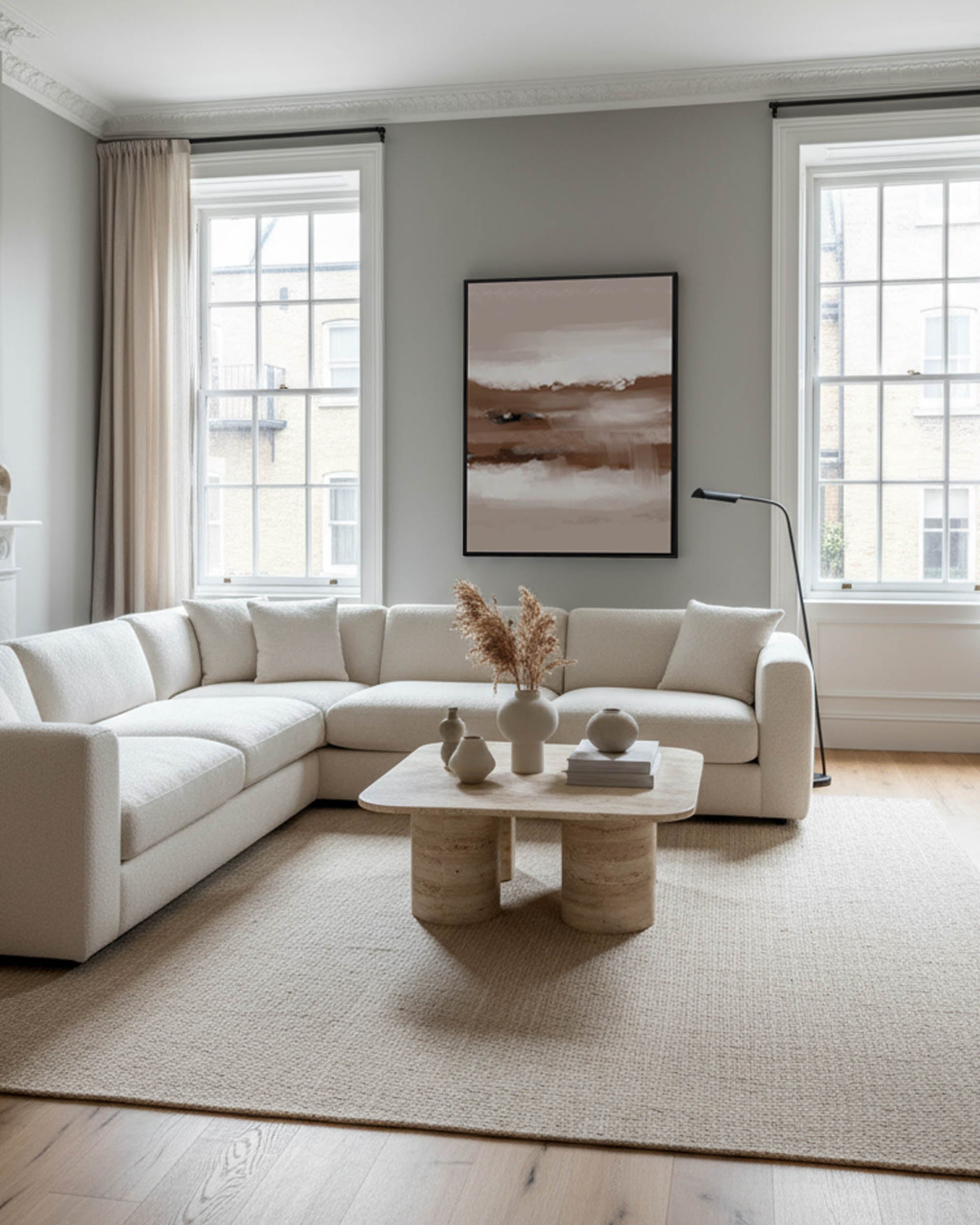 Modern living room with a white sectional sofa, coffee table, and abstract art on the wall.