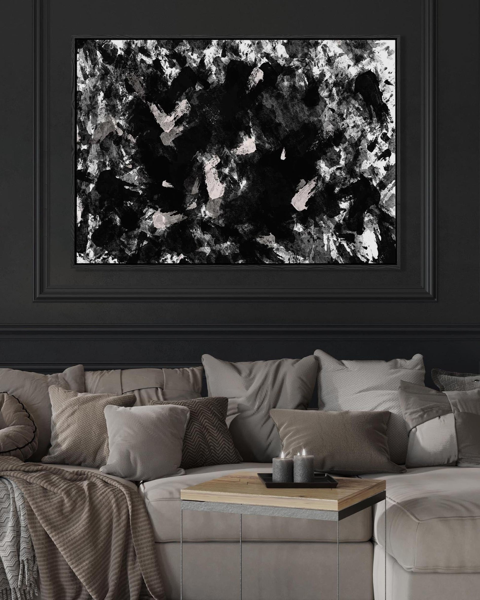 Abstract black and white painting on a dark wall above a gray sofa.