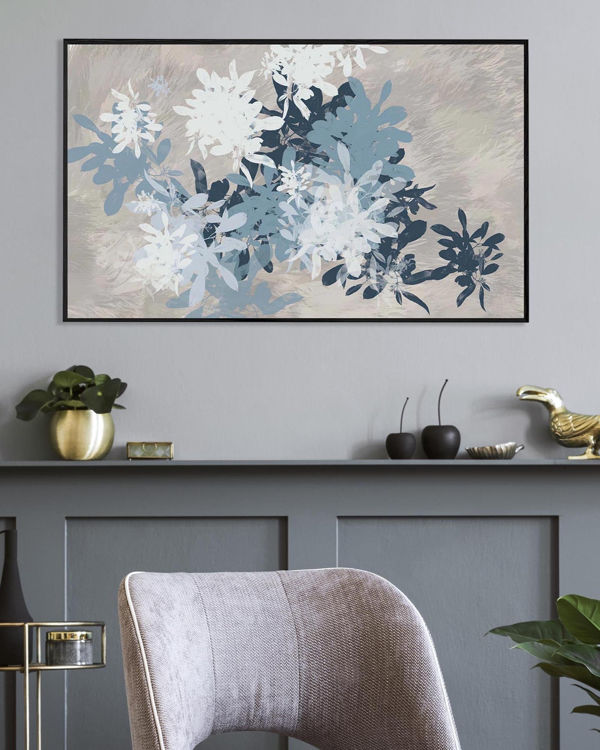 Floral artwork on a wall with decorative items below in a room setting.