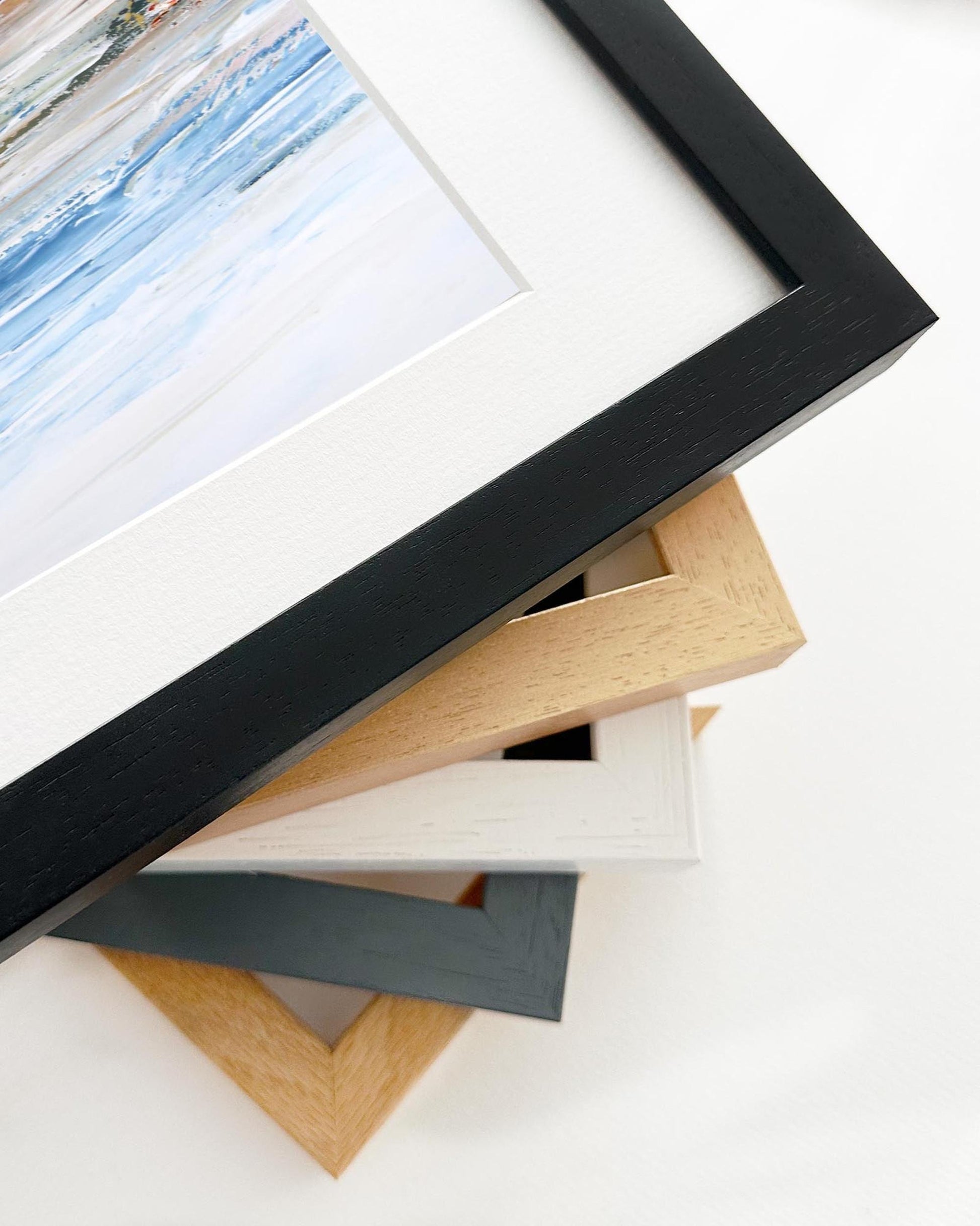 Stack of variously colored picture frames on a white surface