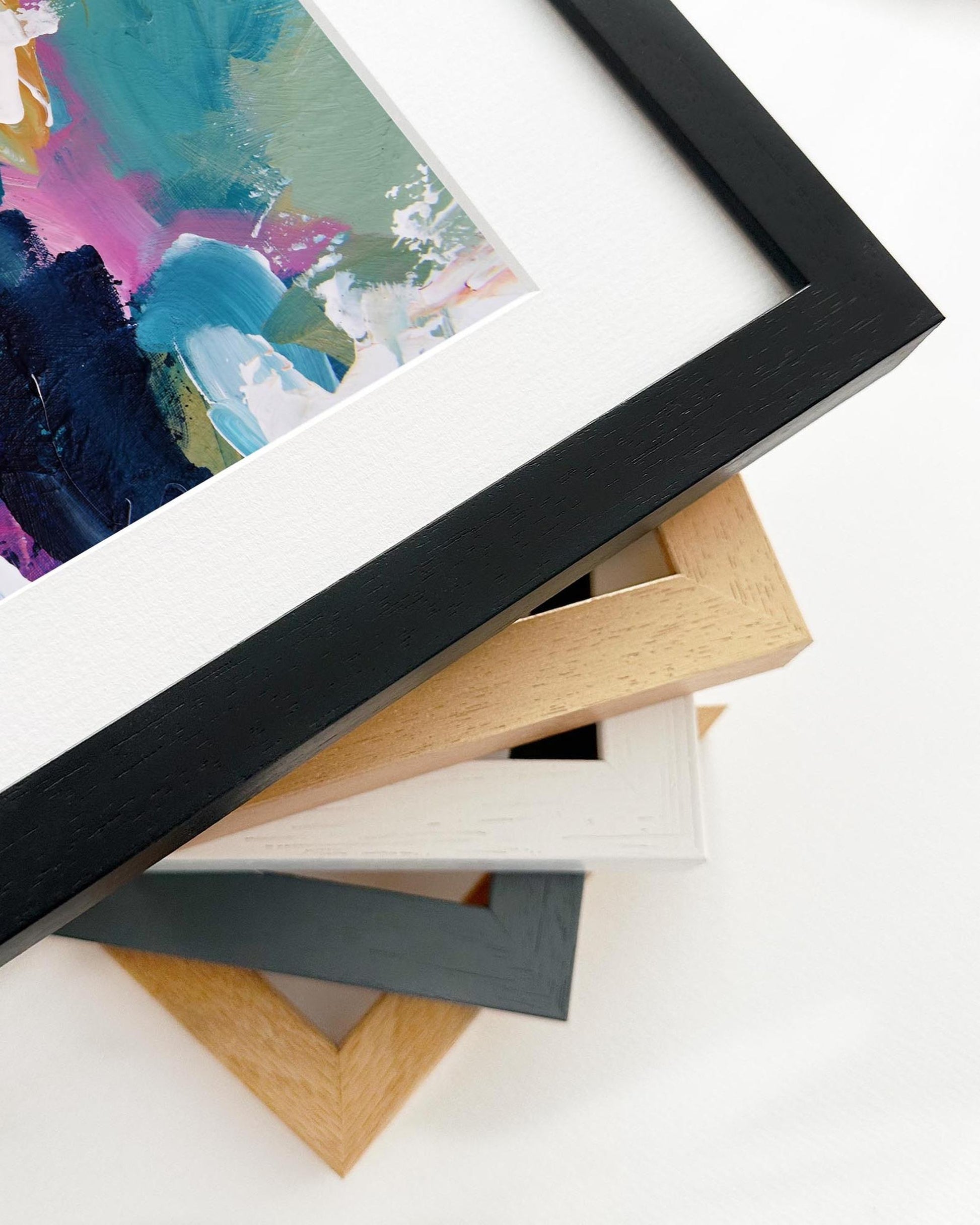 Stack of variously colored picture frames on a white background