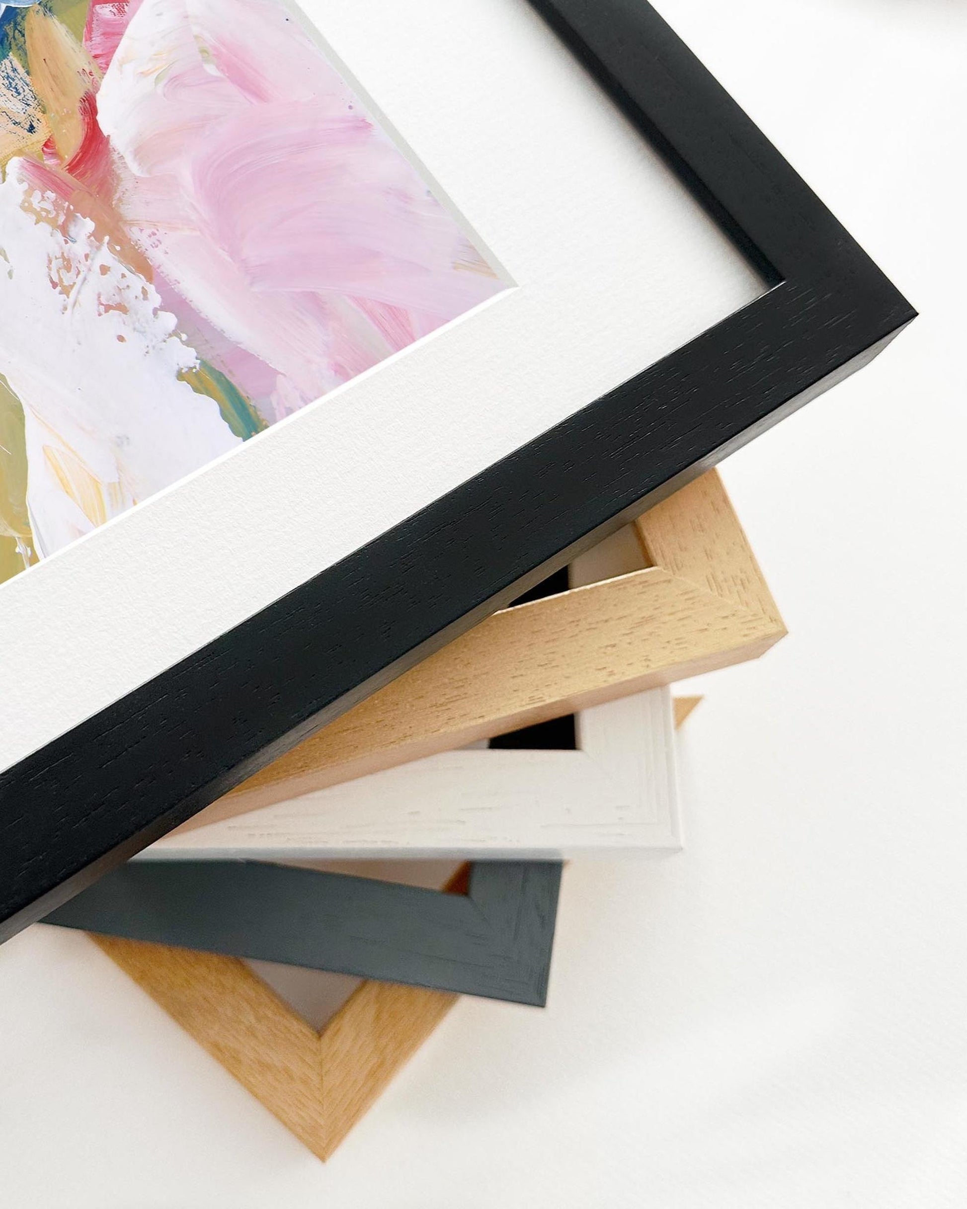 Stack of variously colored picture frames on a white surface