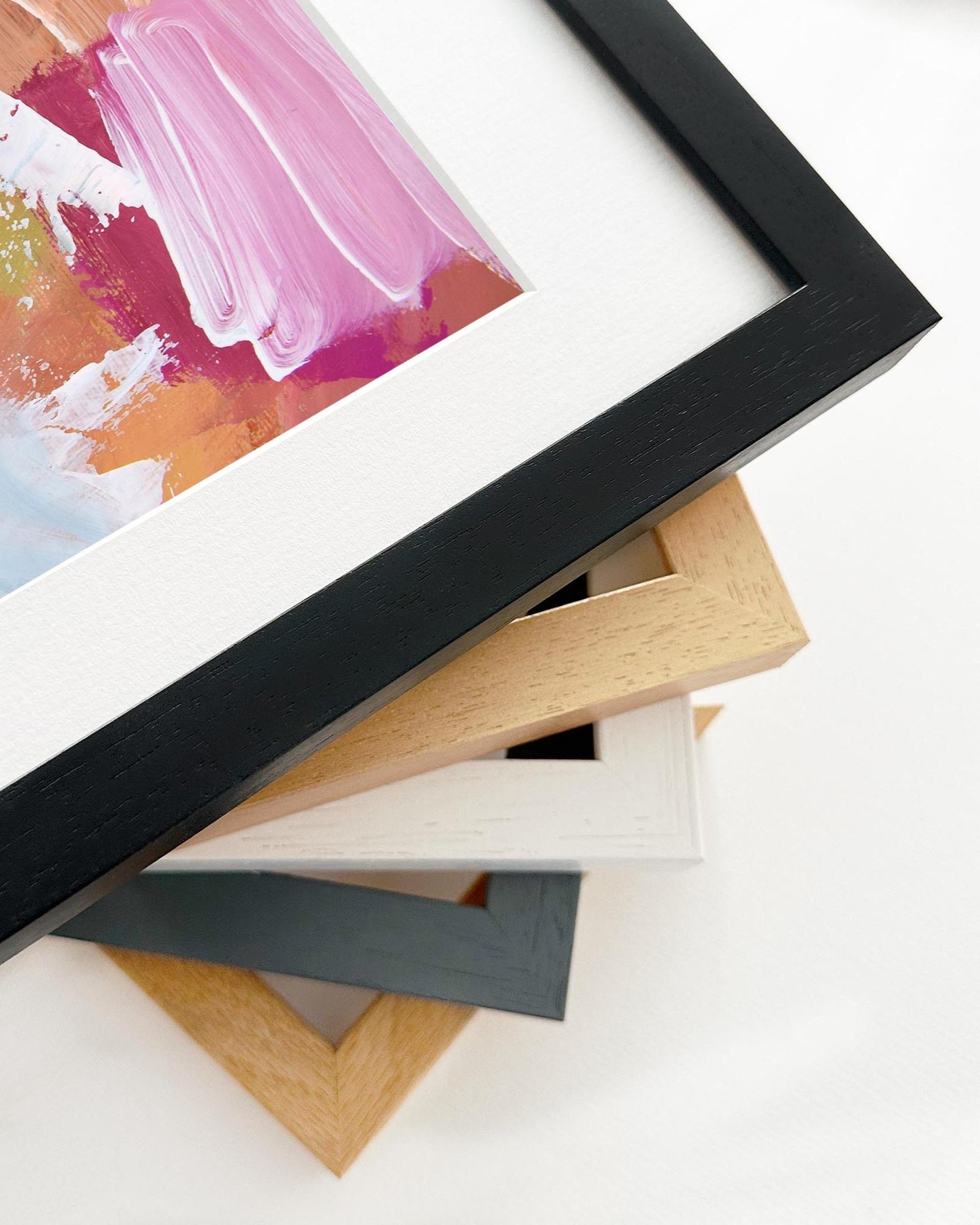Stack of variously colored picture frames on a white background