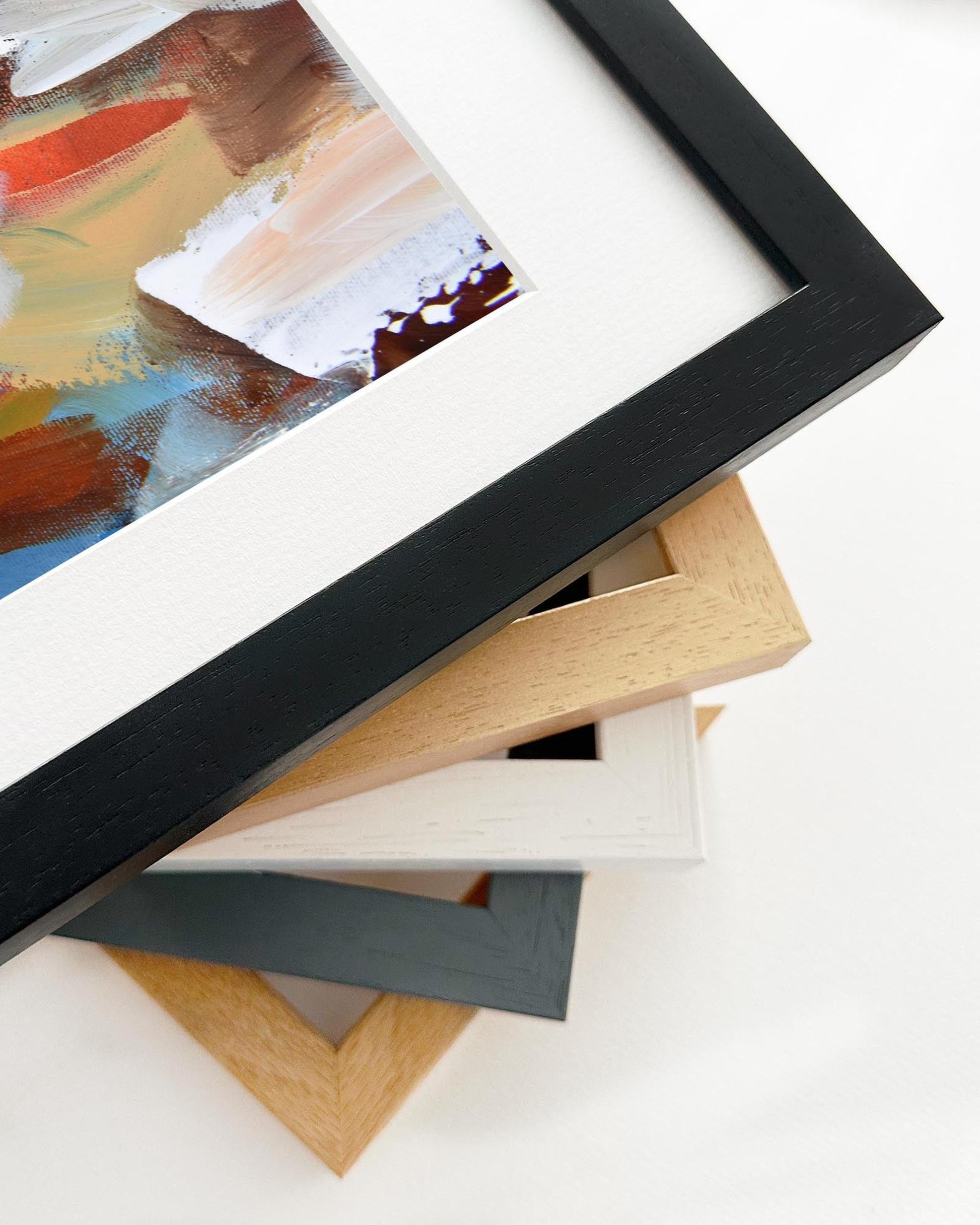 Stack of variously colored picture frames on a white surface