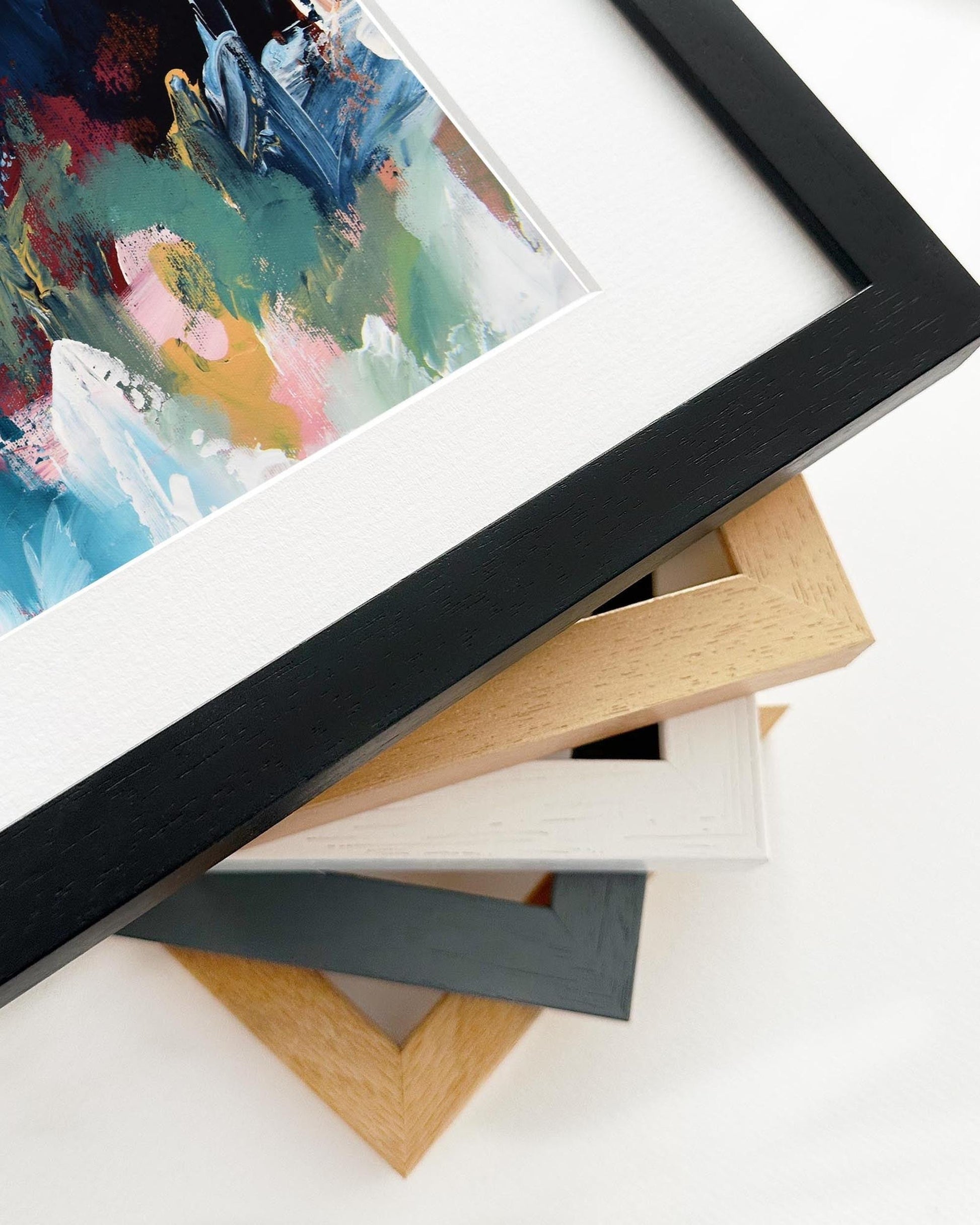 Collection of different colored picture frames on a white surface