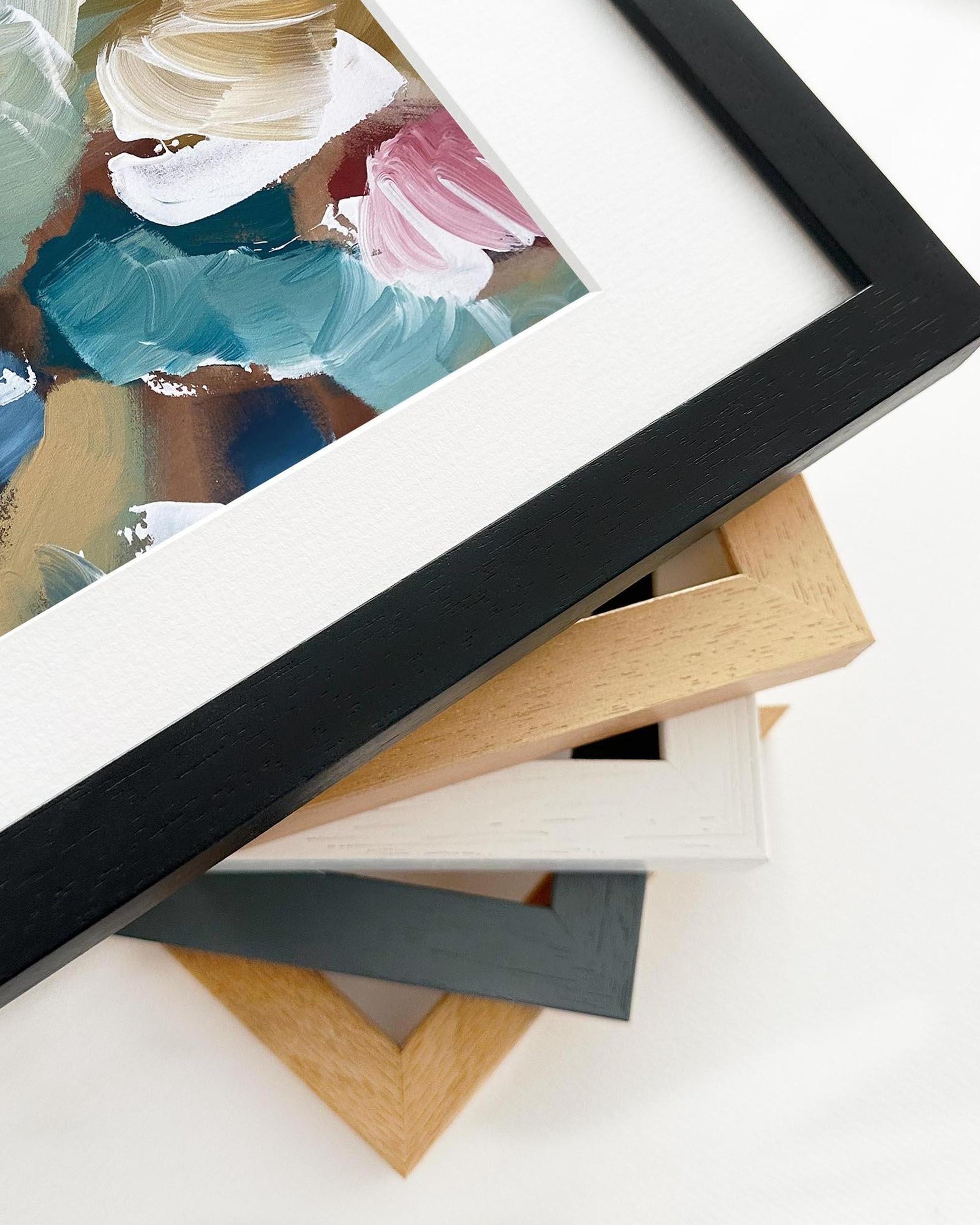 Collection of picture frames with a painting in the background