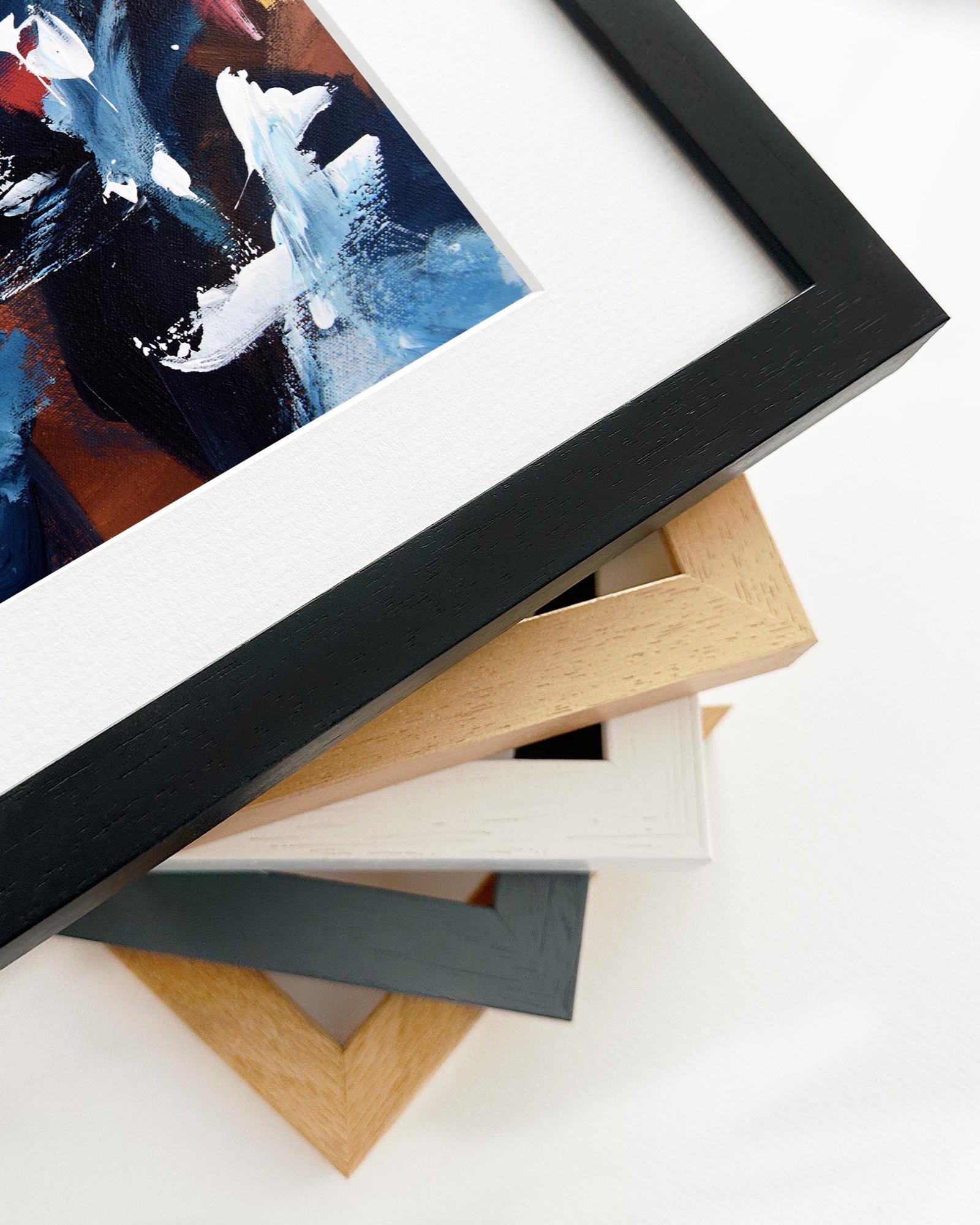 Stack of variously colored picture frames on a white surface