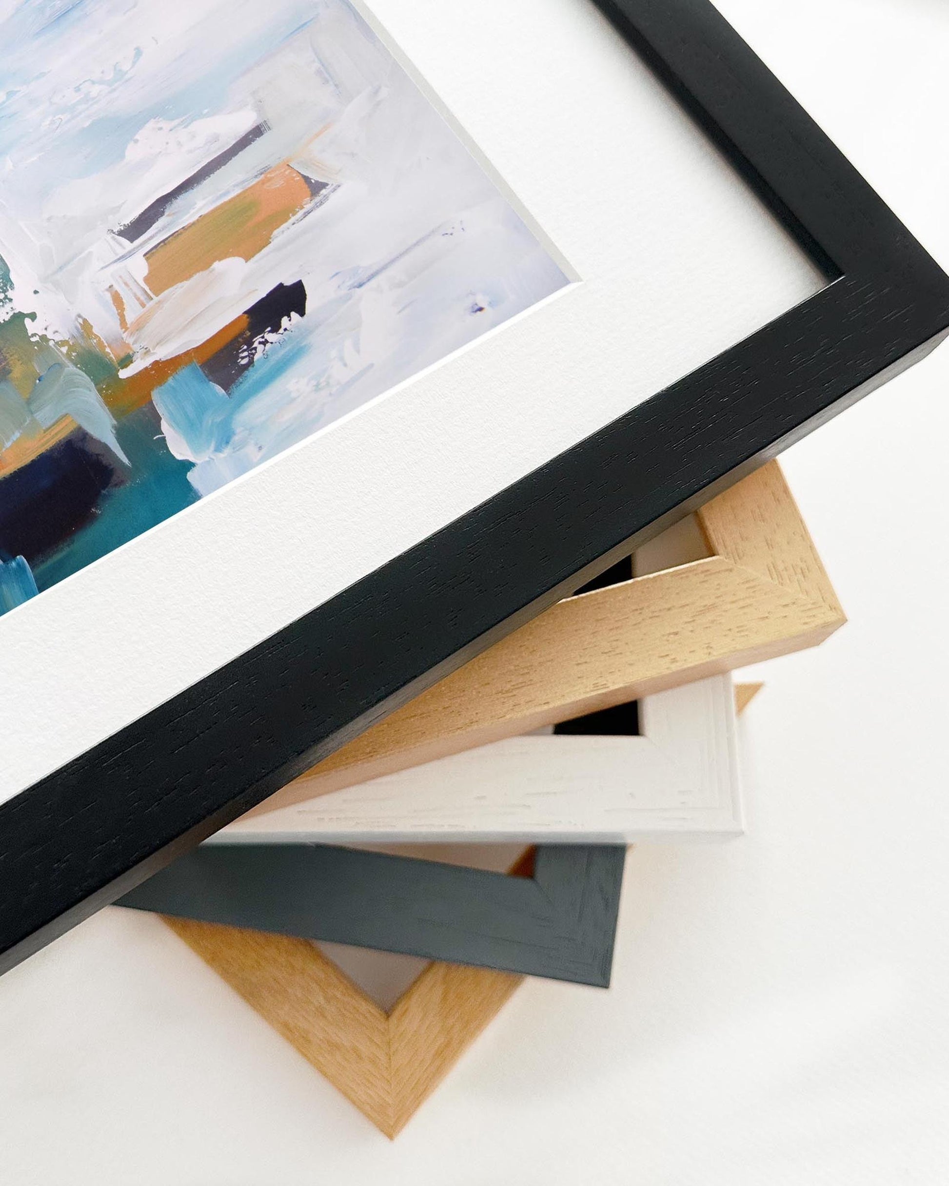 Stack of variously colored picture frames on a white surface