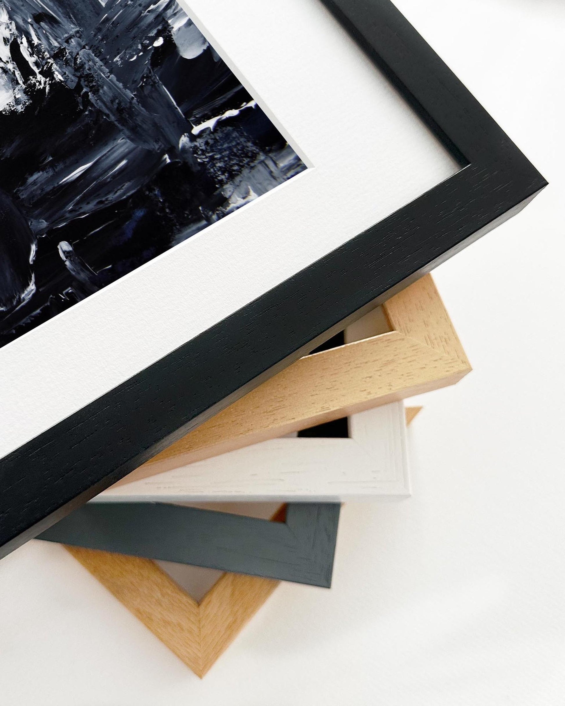 Stack of variously colored picture frames on a white surface