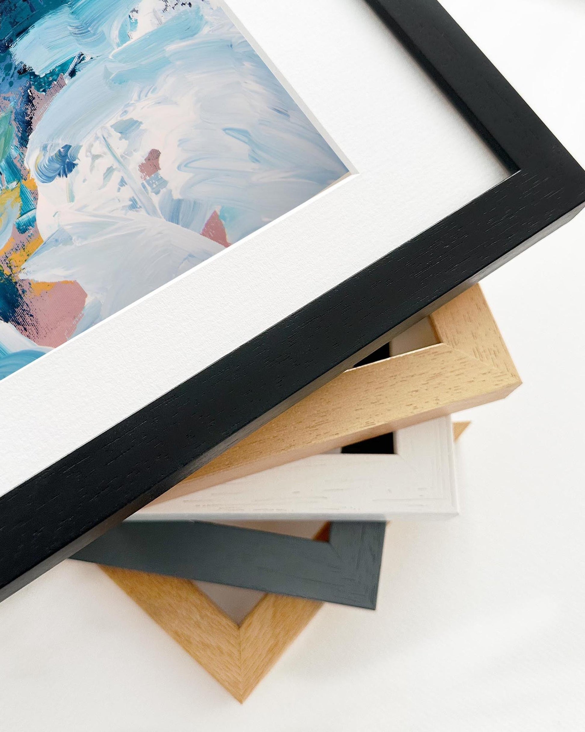 Stack of variously colored picture frames on a white surface