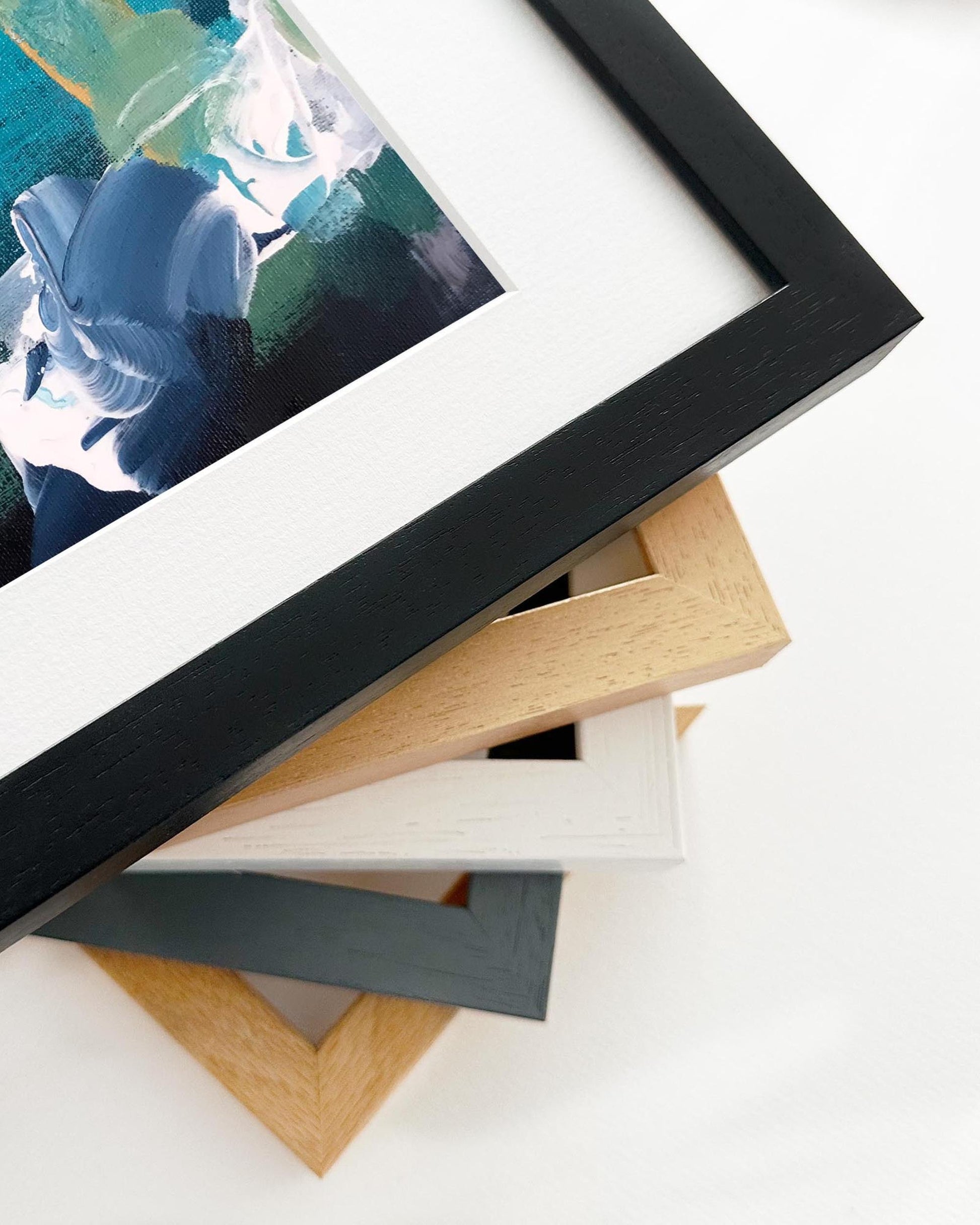 Stack of variously colored picture frames on a white surface