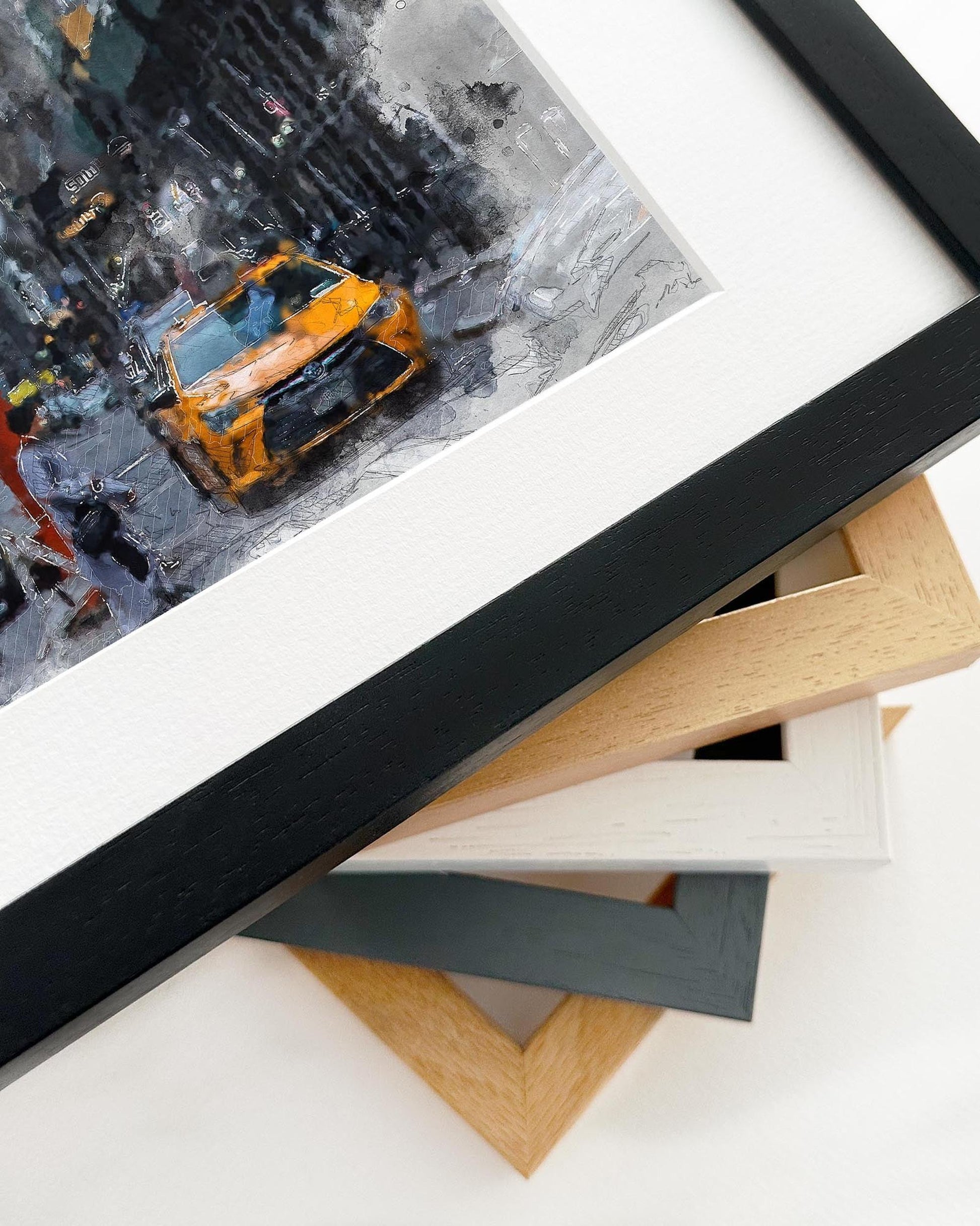 Framed photograph of a snowy street scene with a yellow taxi, surrounded by other frames.