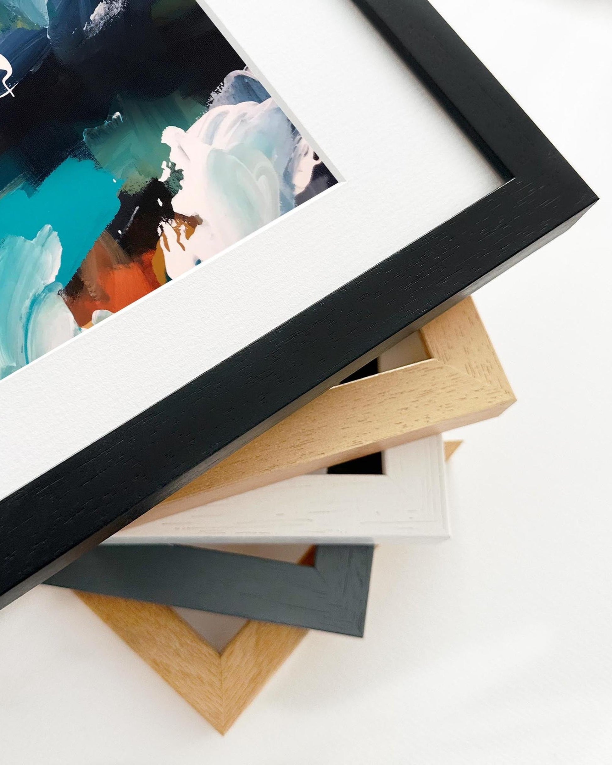 Stack of variously colored picture frames on a white surface