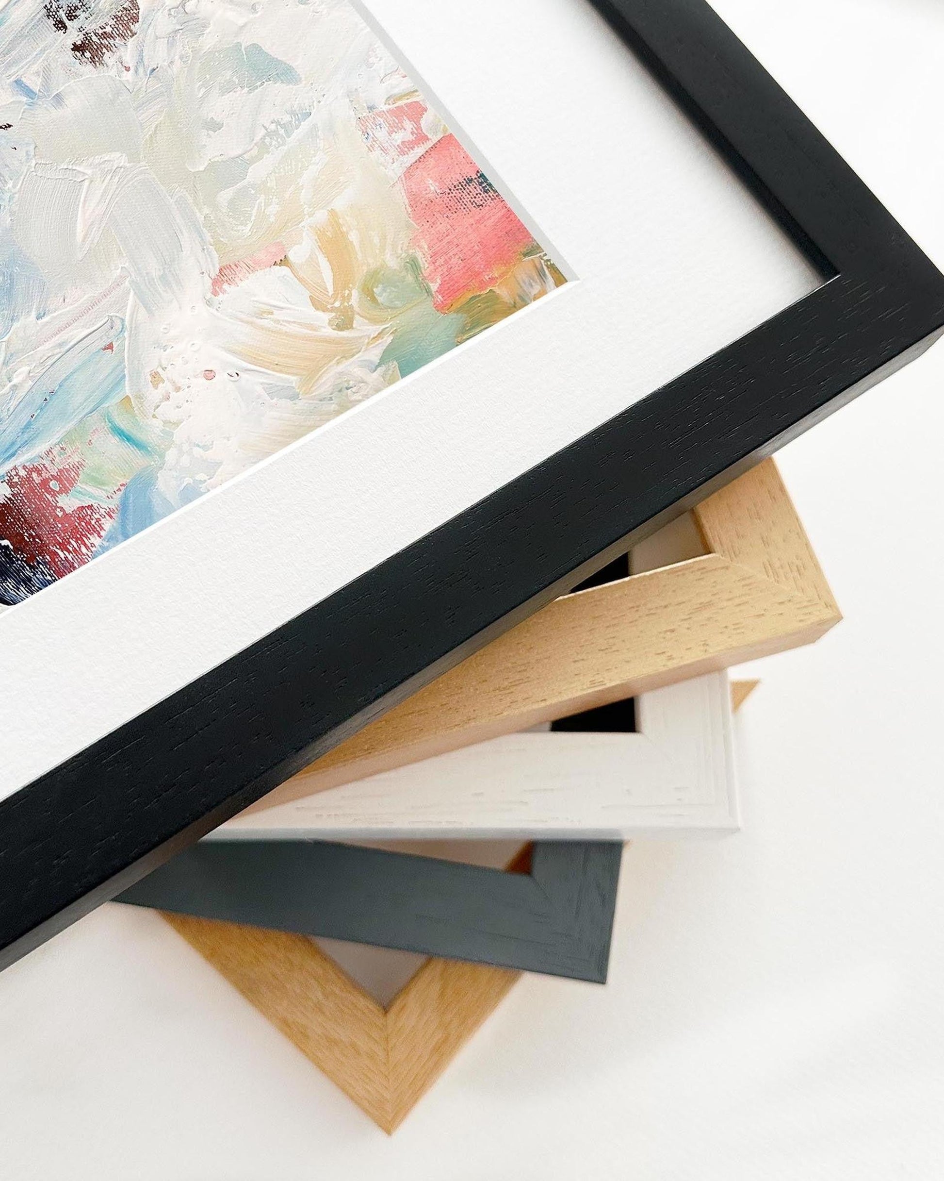 Stack of various picture frames on a white surface