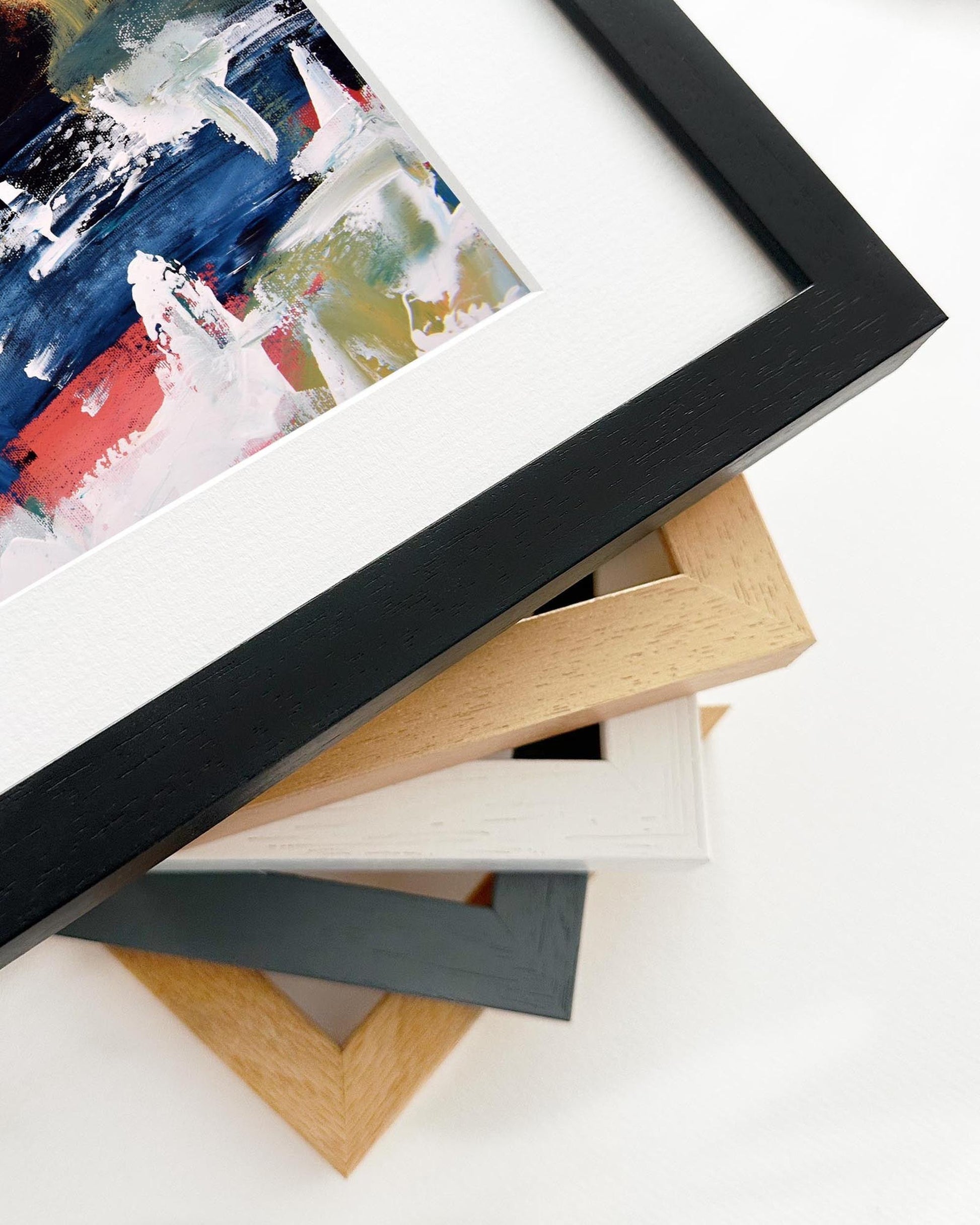 Stack of variously colored picture frames on a white surface
