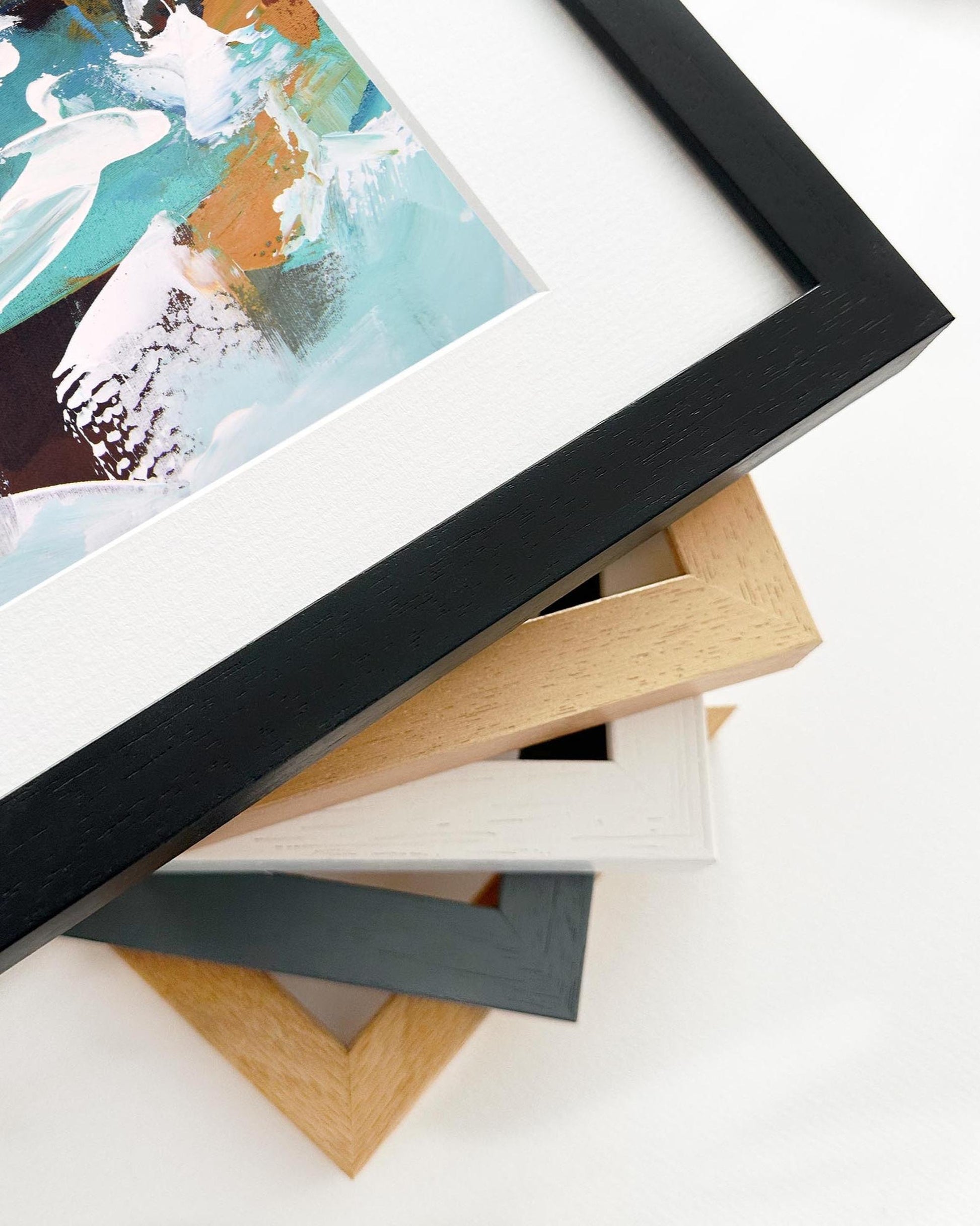 Stack of variously colored picture frames on a white surface