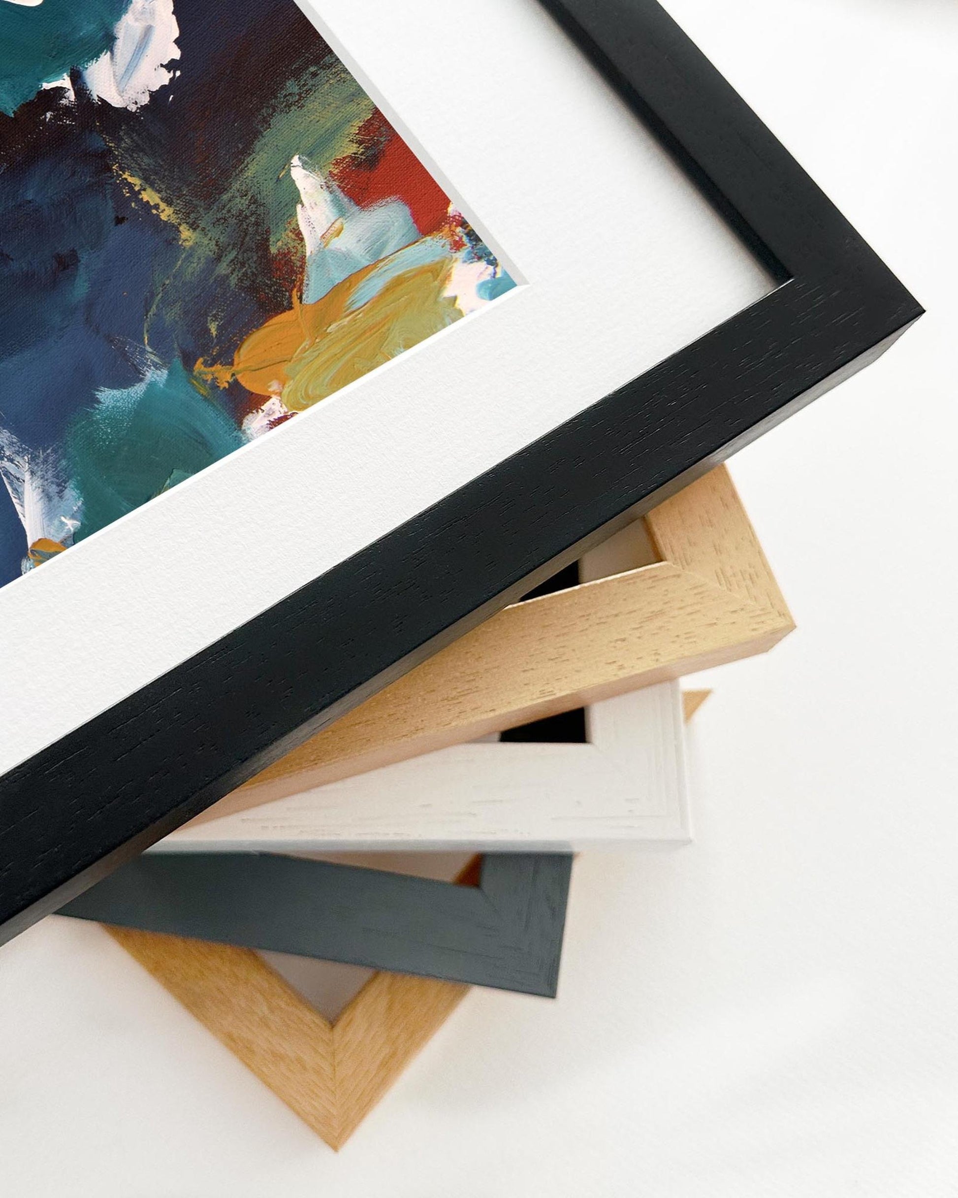 Stack of variously colored picture frames on a white surface