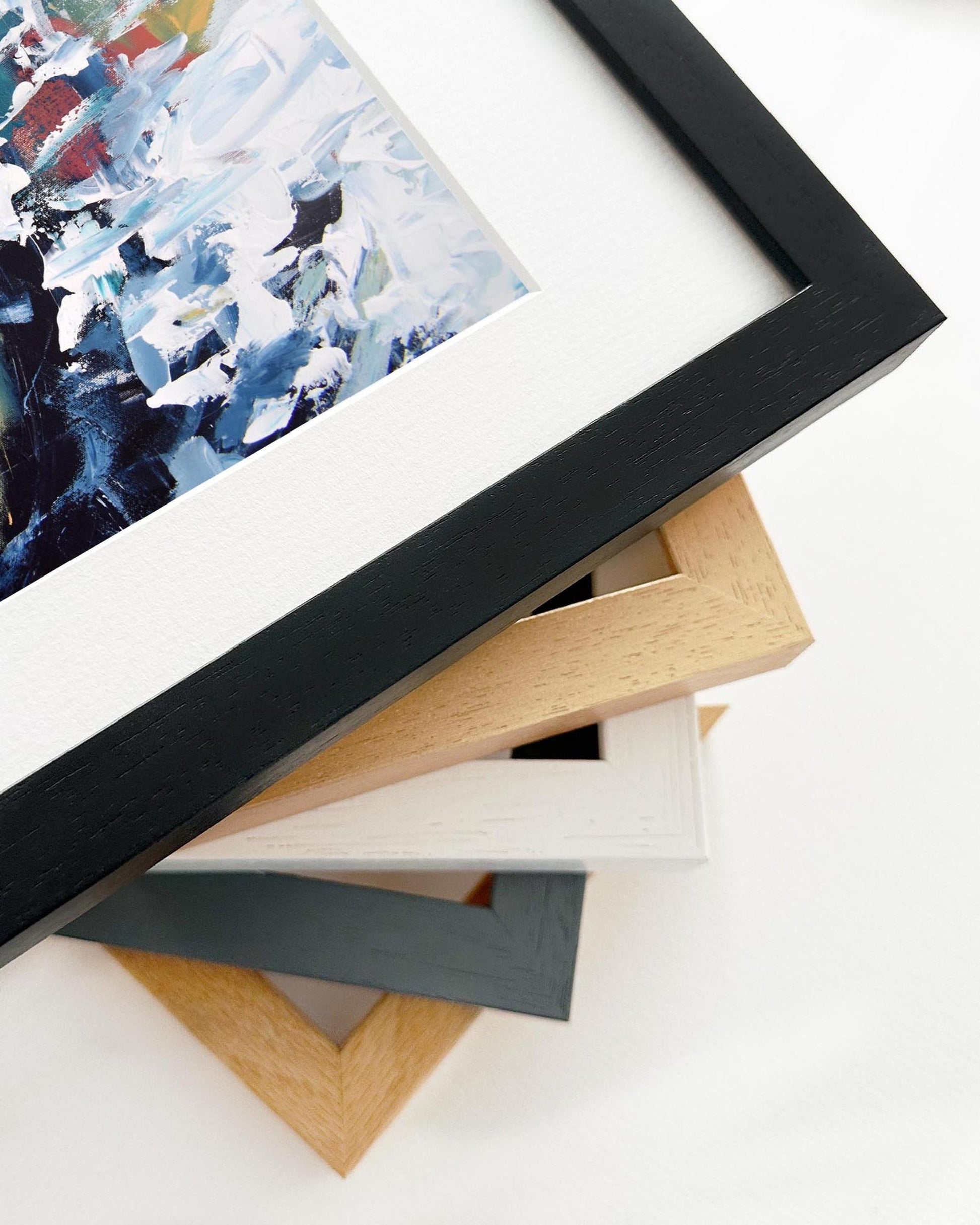 Framed abstract artwork with various frame options on a white surface