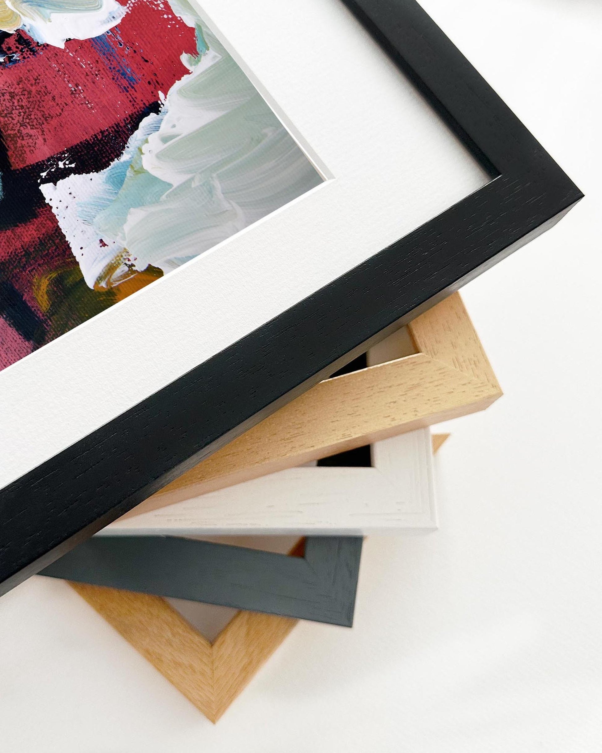 Stack of variously colored picture frames on a white surface